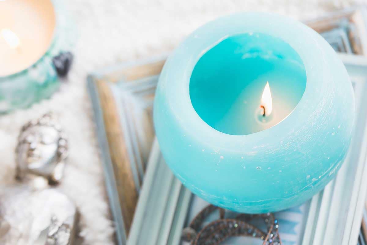 Moody image of a lit blue-cyan candle resting on top of framed photographs, symbolizing deep experience and real estate knowledge.