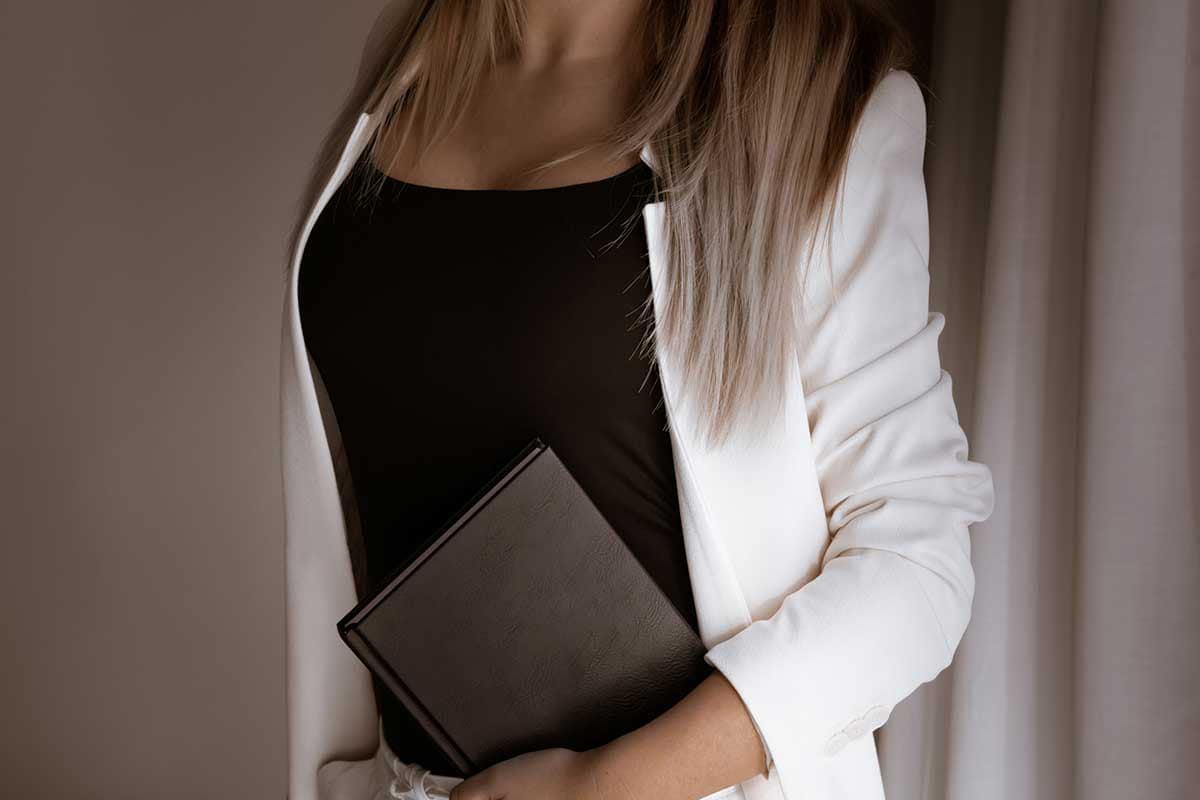 Professional woman holding a notebook, symbolizing a strong network of trusted real estate experts available to provide quick and accurate support.