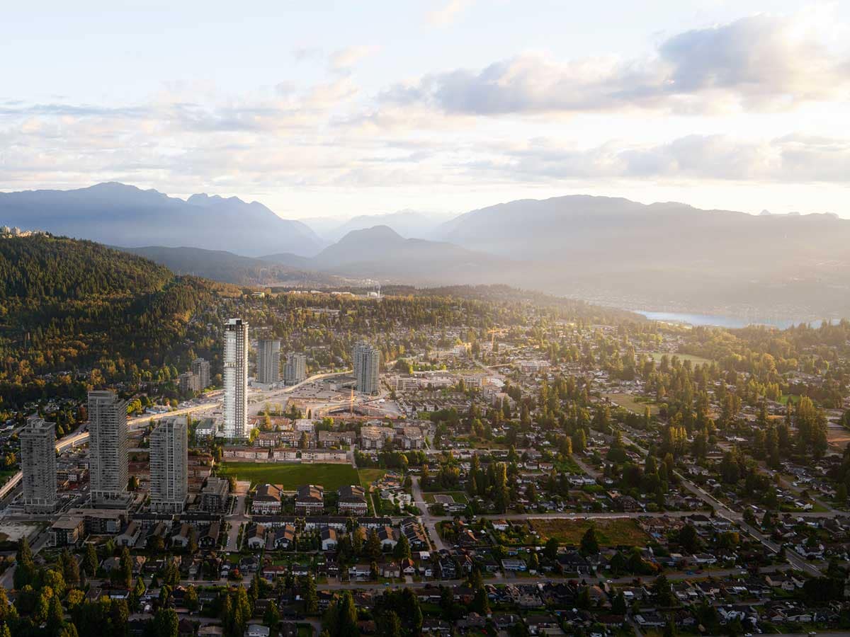 Aerial view of Coquitlam neighbourhoods with residential homes, high-rise towers, and surrounding mountains, illustrating areas for presale condos and new homes.