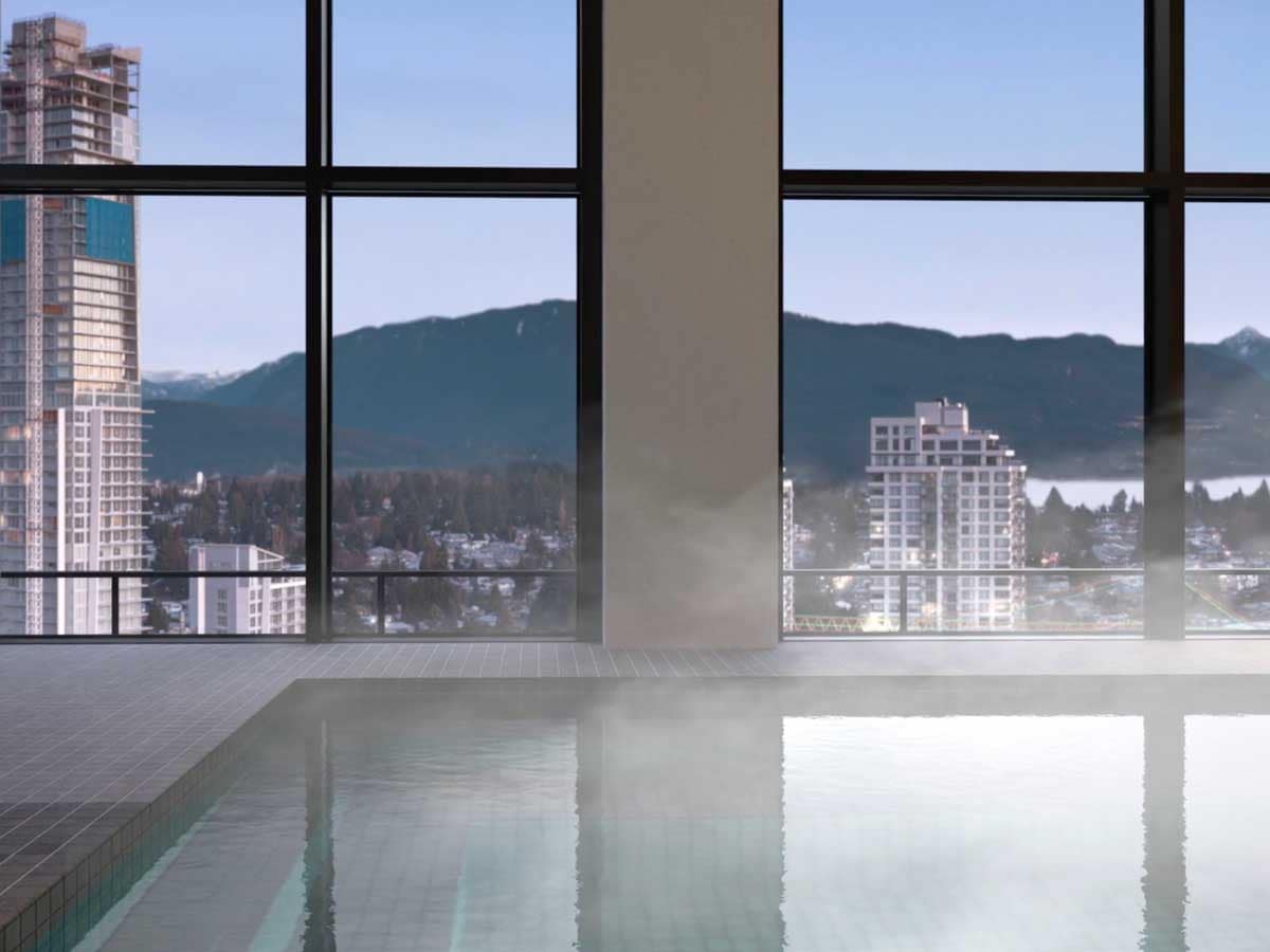 Indoor pool amenity in Coquitlam presale condos with large windows overlooking city skyline and mountains, highlighting luxury features in new homes.