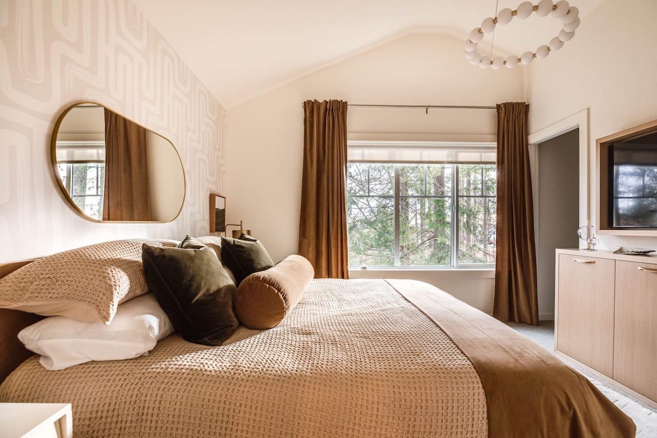 Elegant primary bedroom with warm tones and large window at The Loop South Surrey