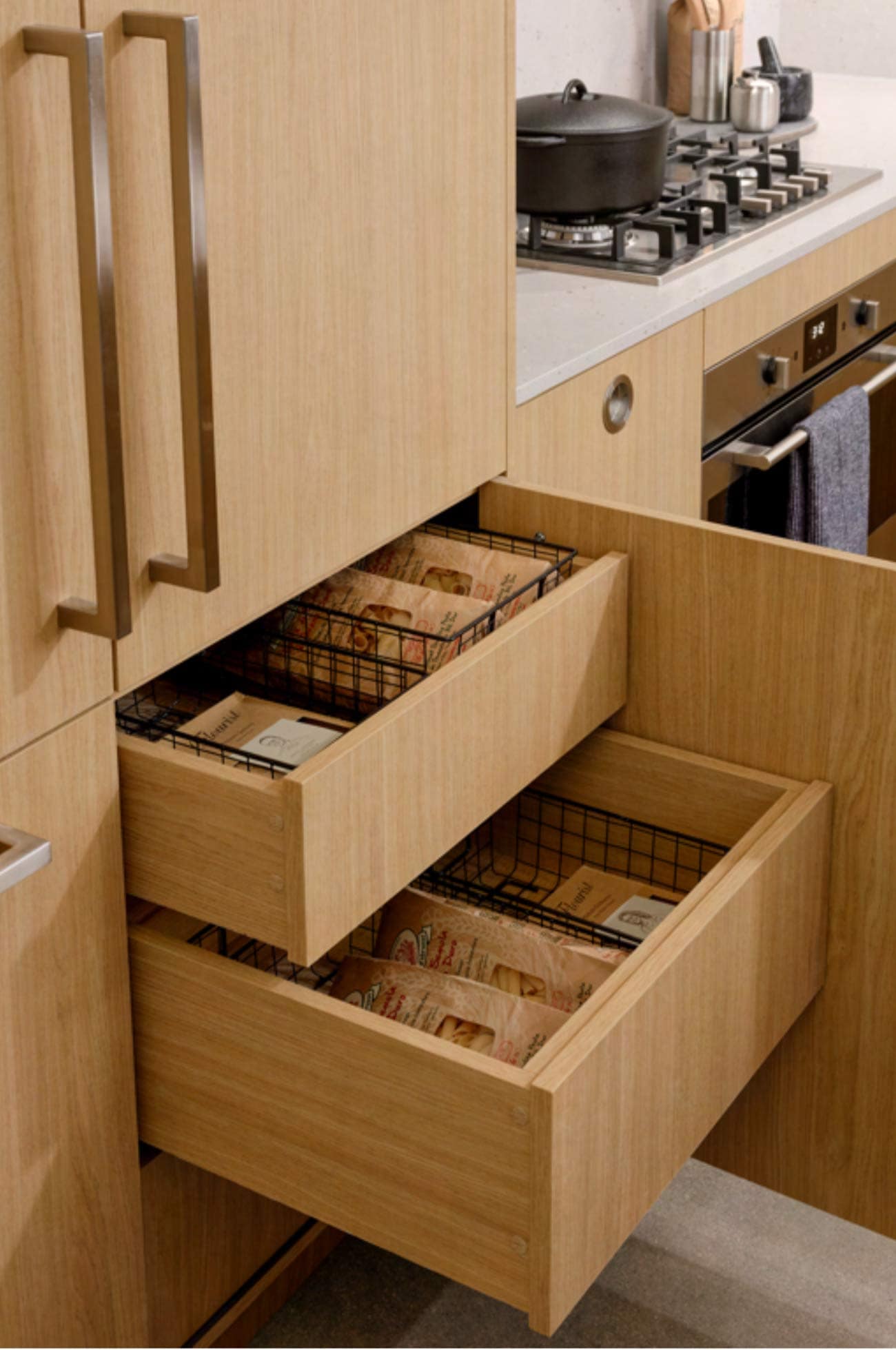Kitchen storage at Hem Vancouver by Hudson featuring pull-out drawers, built-in organizers, and wood cabinetry near cooking area at 385 Lakewood Drive