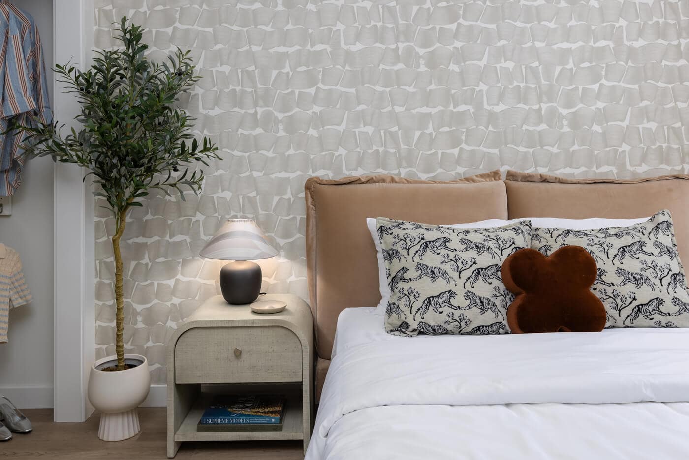 Bedroom interior at Jericho Park Langley by Essence Properties featuring modern wallpaper, upholstered bed, soft lighting, and contemporary dรฉcor at 19925 78B Avenue.