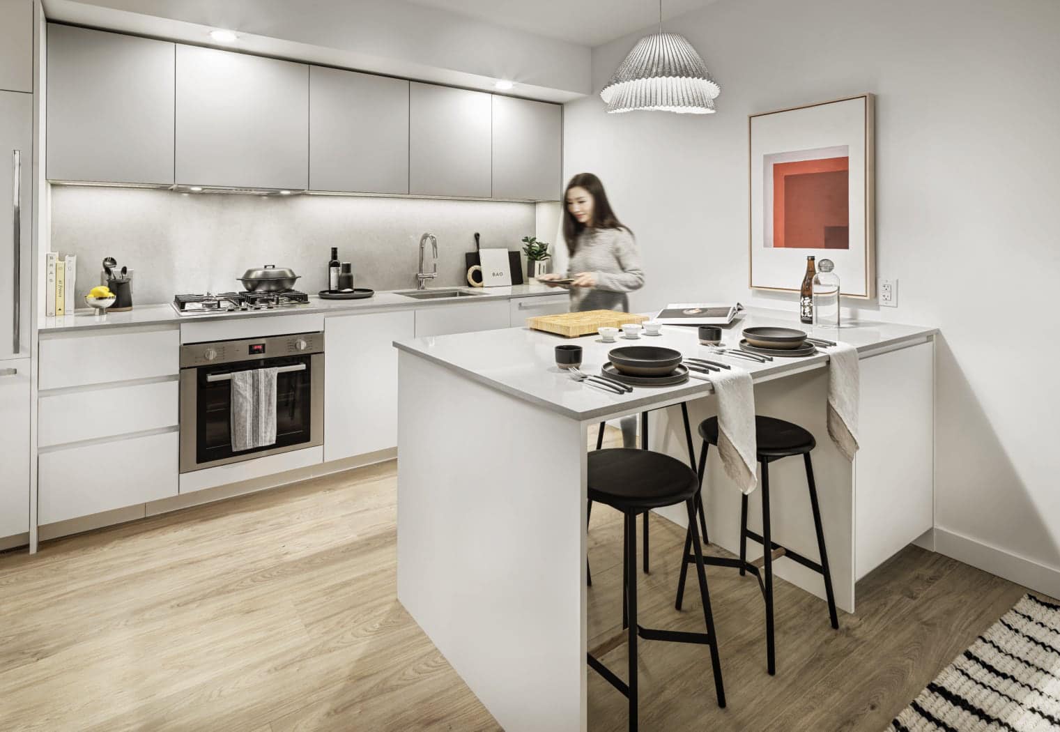 Stylish kitchen at Gardena Coquitlam by Intracorp at 635 Gardena Drive, featuring a large island with bar seating, integrated appliances, modern cabinetry, and bright finishes designed for both cooking and entertaining in Burquitlam.