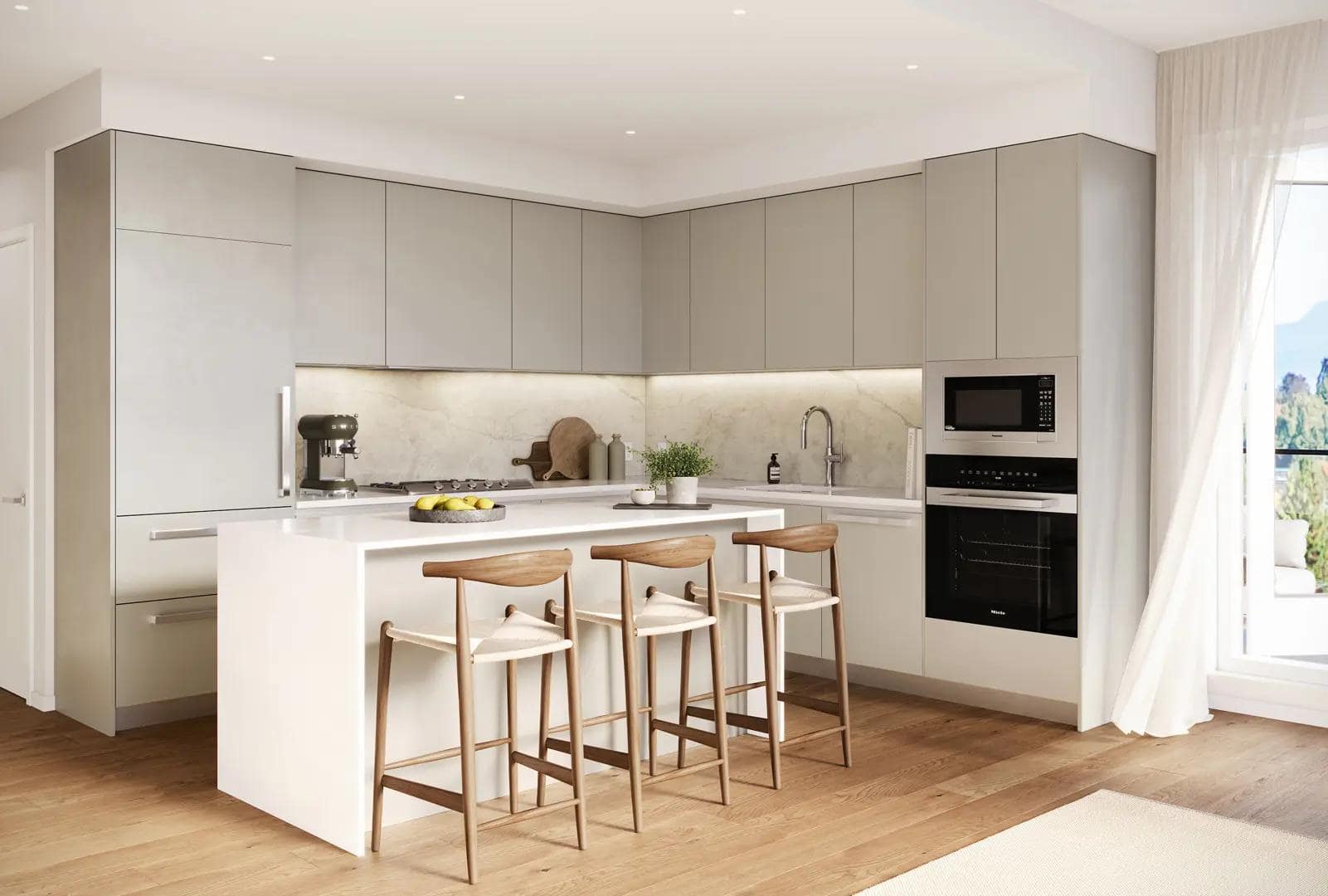 Modern kitchen interior at Arden presale development in Vancouverโs Cambie neighbourhood, featuring matte grey flat-panel cabinetry, integrated appliances, quartz waterfall island with bar seating, and warm wood flooring by Aria Pacific Development at 4281 Cambie Street.