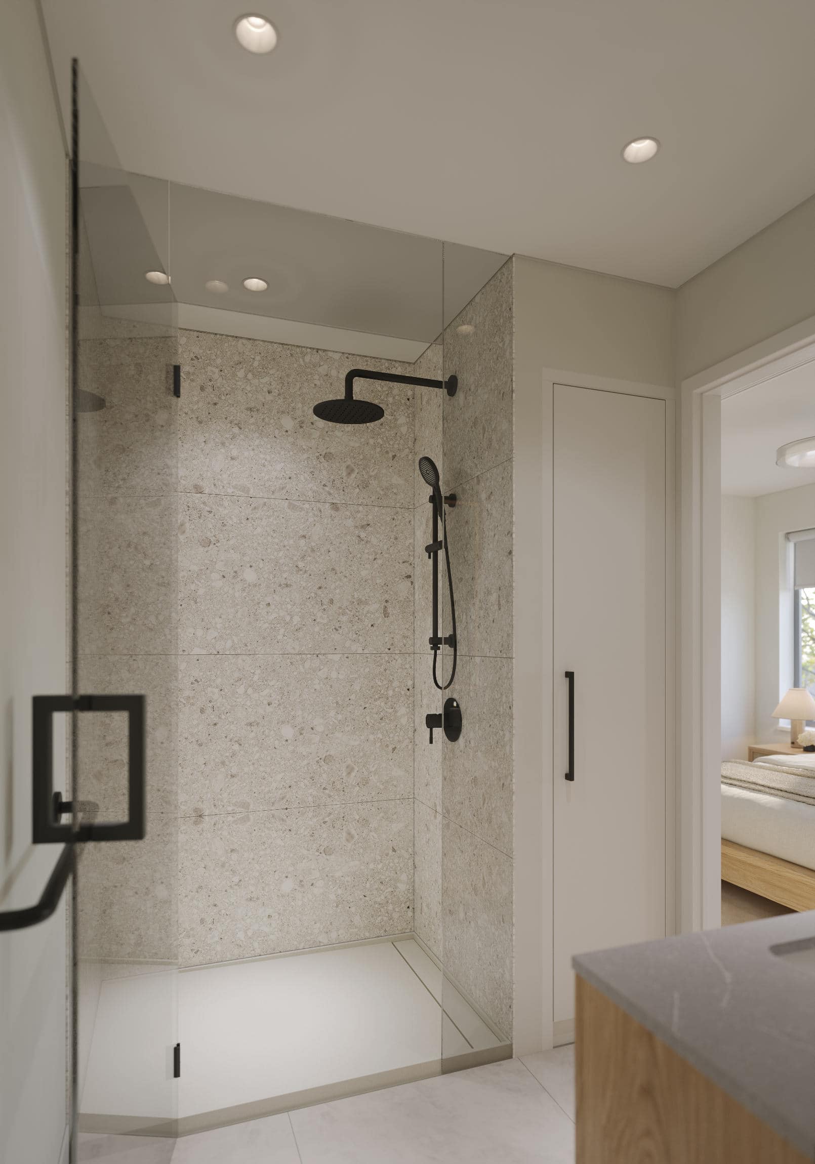 Walk-in shower at Quintet Vancouver East with large-format stone tile walls, matte black fixtures, glass enclosure, and clean modern design by THT Properties in Vancouver East.