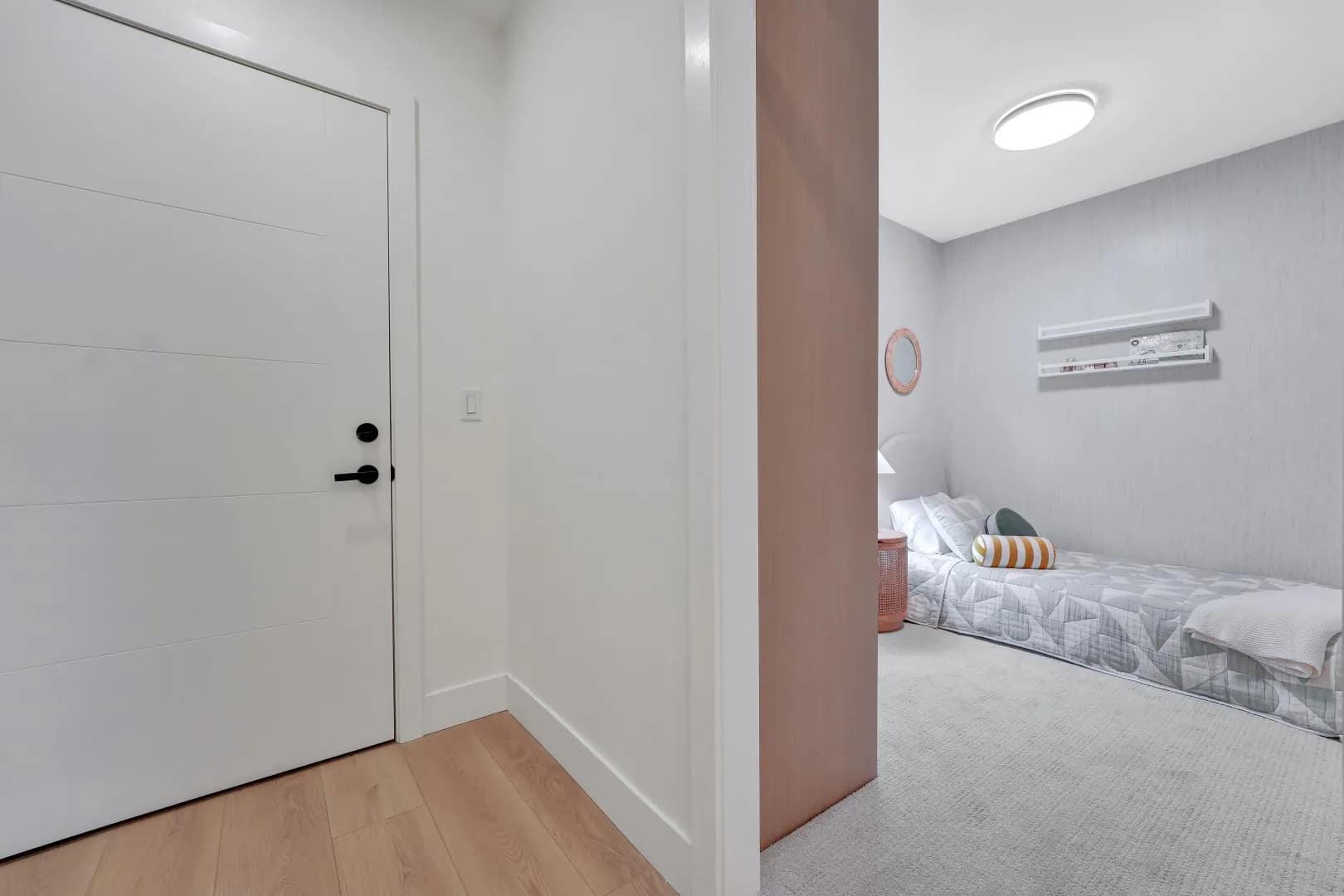 Interior bedroom entry at Jethro Langley showing modern door, soft carpet flooring, and compact bedroom layout in a presale condo by Whitetail Homes in Langley City