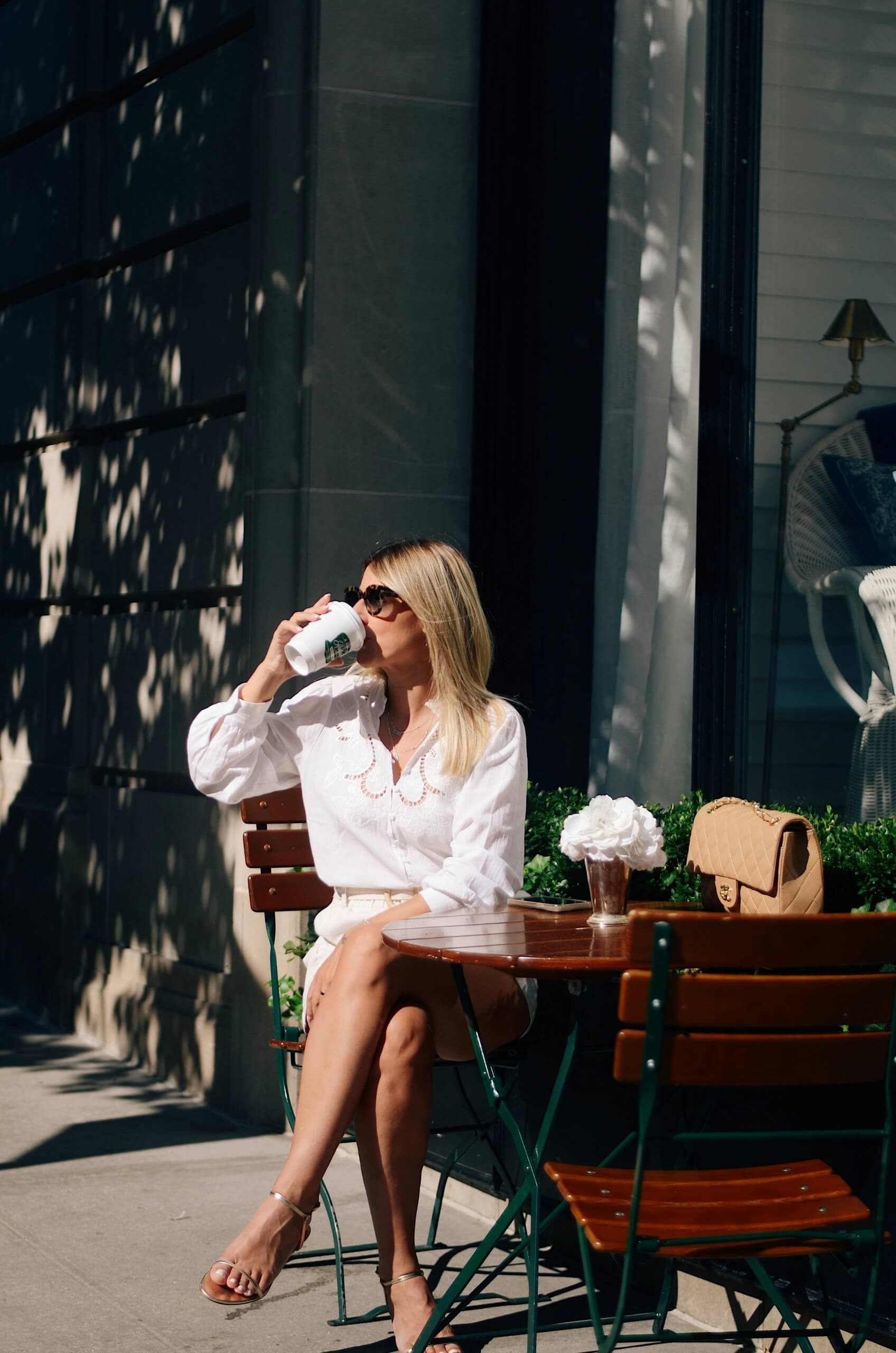 Woman enjoying coffee at an outdoor café patio in Burnaby’s Capitol Hill neighbourhood near Centrale Burnaby by FirstTrack Development at 4488 Hastings Street.