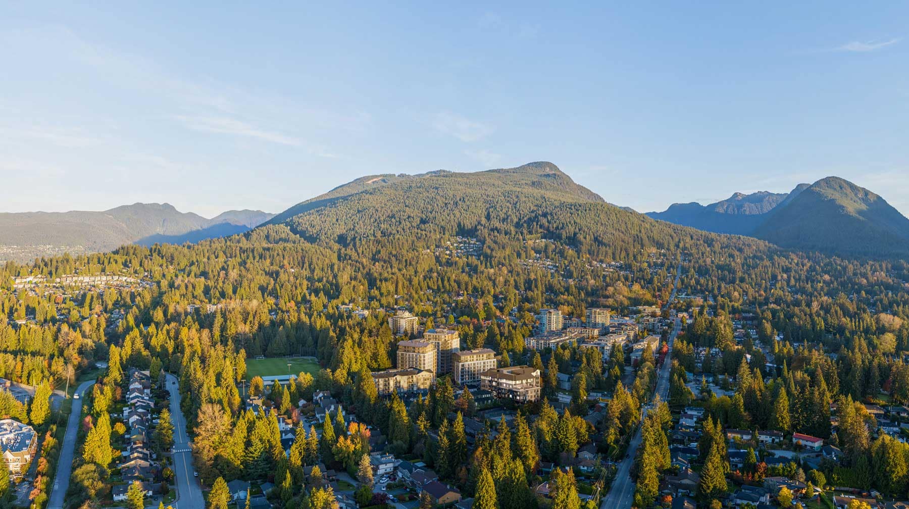 Aerial view of the Lynn Valley neighbourhood surrounding Trailside at Lynn in North Vancouver, highlighting forested mountains, residential streets, and the natural setting near 2380 Emery Court.
