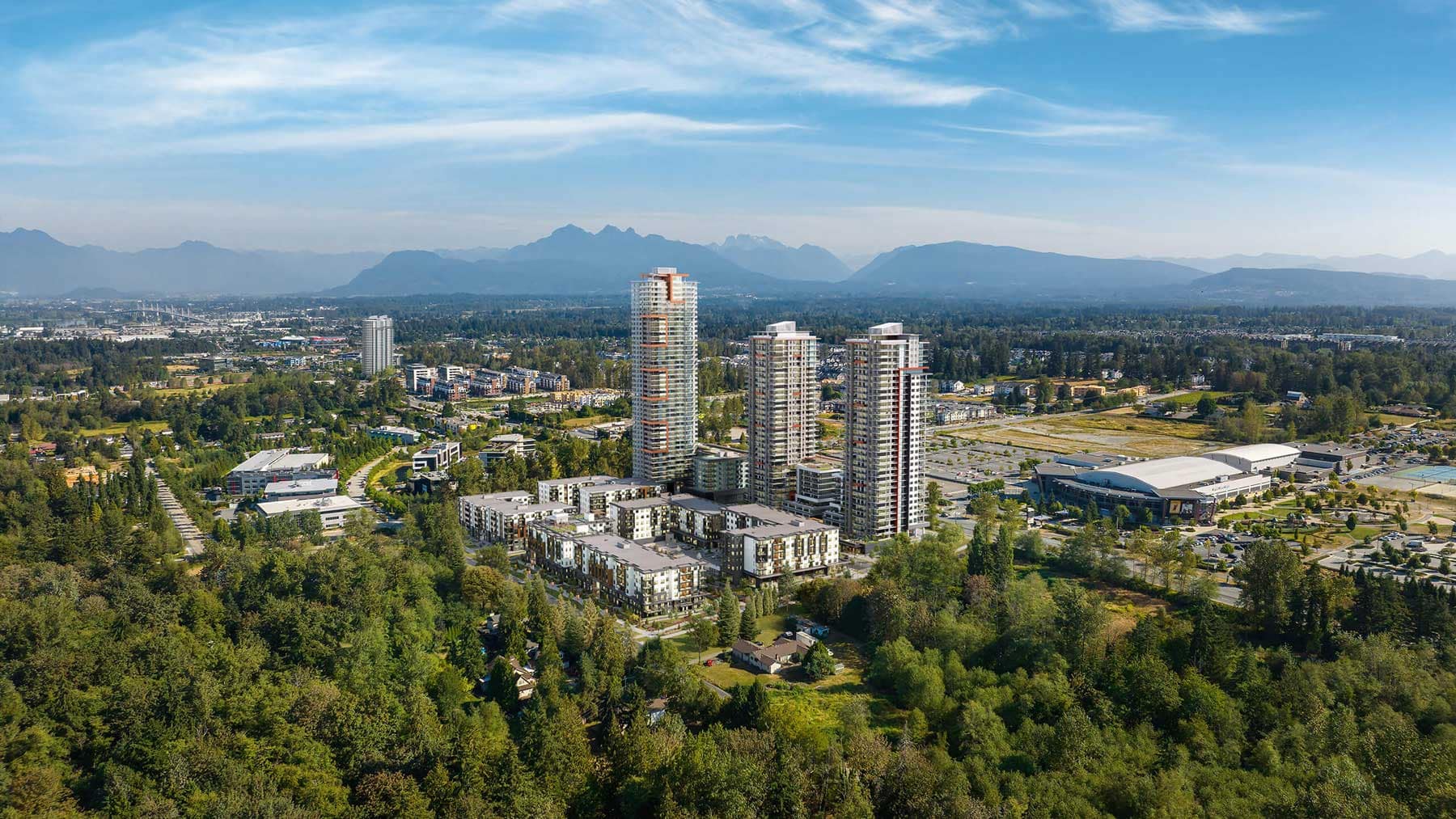 Aerial view of Jericho Park Langley presale community by Essence Properties showing residential towers, low-rise buildings, surrounding greenery, and mountain views near 19925 78B Avenue in Langley.