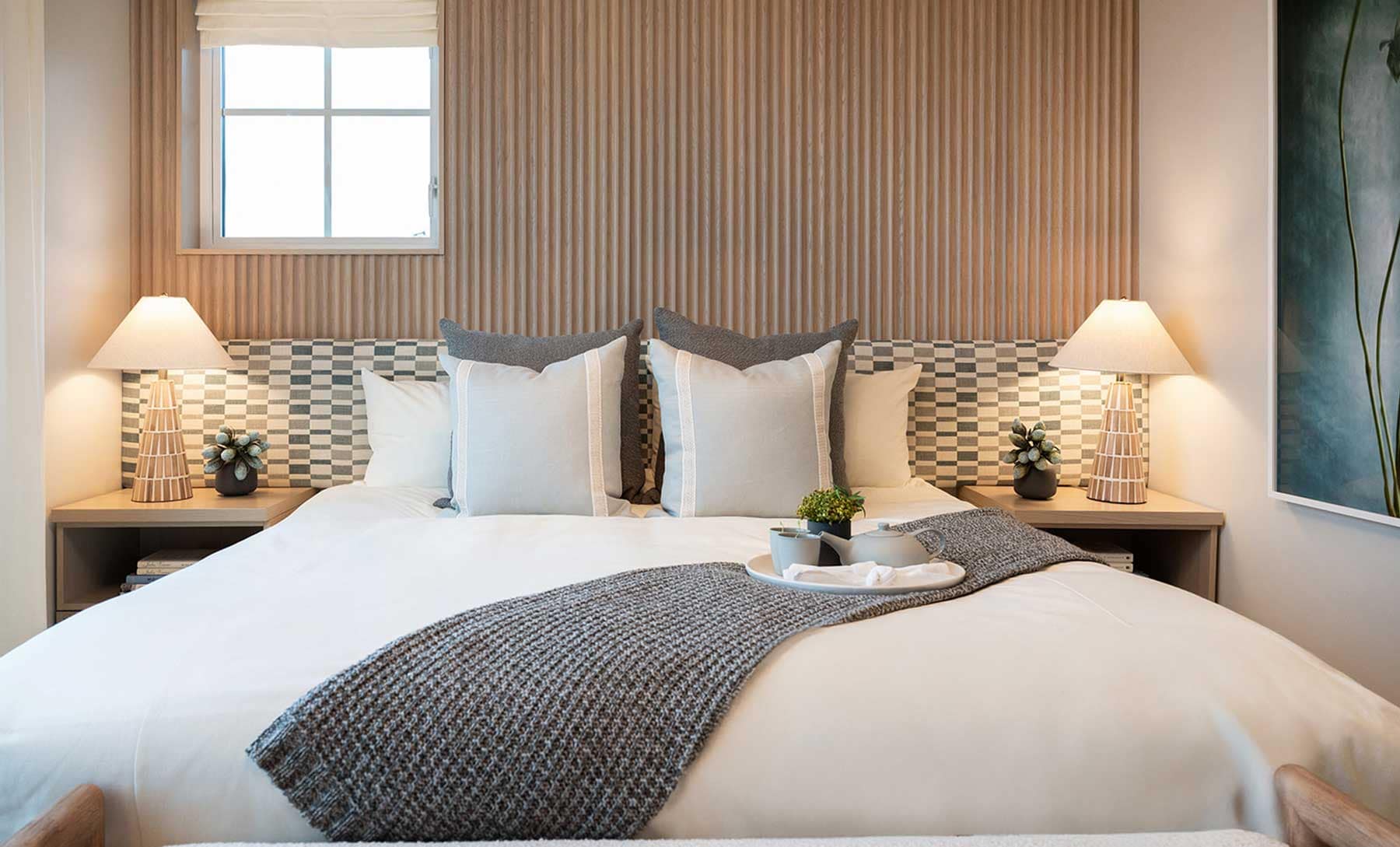 Primary bedroom inside a Beaumont Burke Mountain townhome by Polygon at 3630 Harper Road in Coquitlam, featuring a spacious layout, wood feature wall, large bed, contemporary lighting, and warm, modern interior finishes designed for family living.