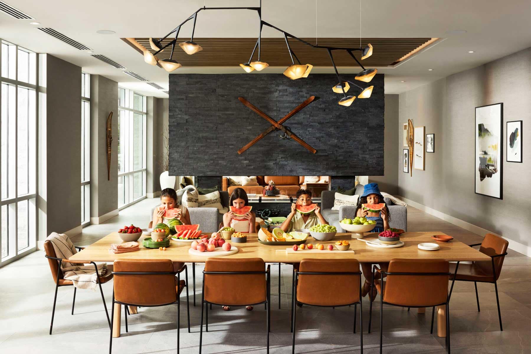 Shared residents lounge and dining amenity at Trailside at Lynn by Mosaic in North Vancouver featuring contemporary furnishings, fireplace feature wall, large communal dining table, and family gathering space.
