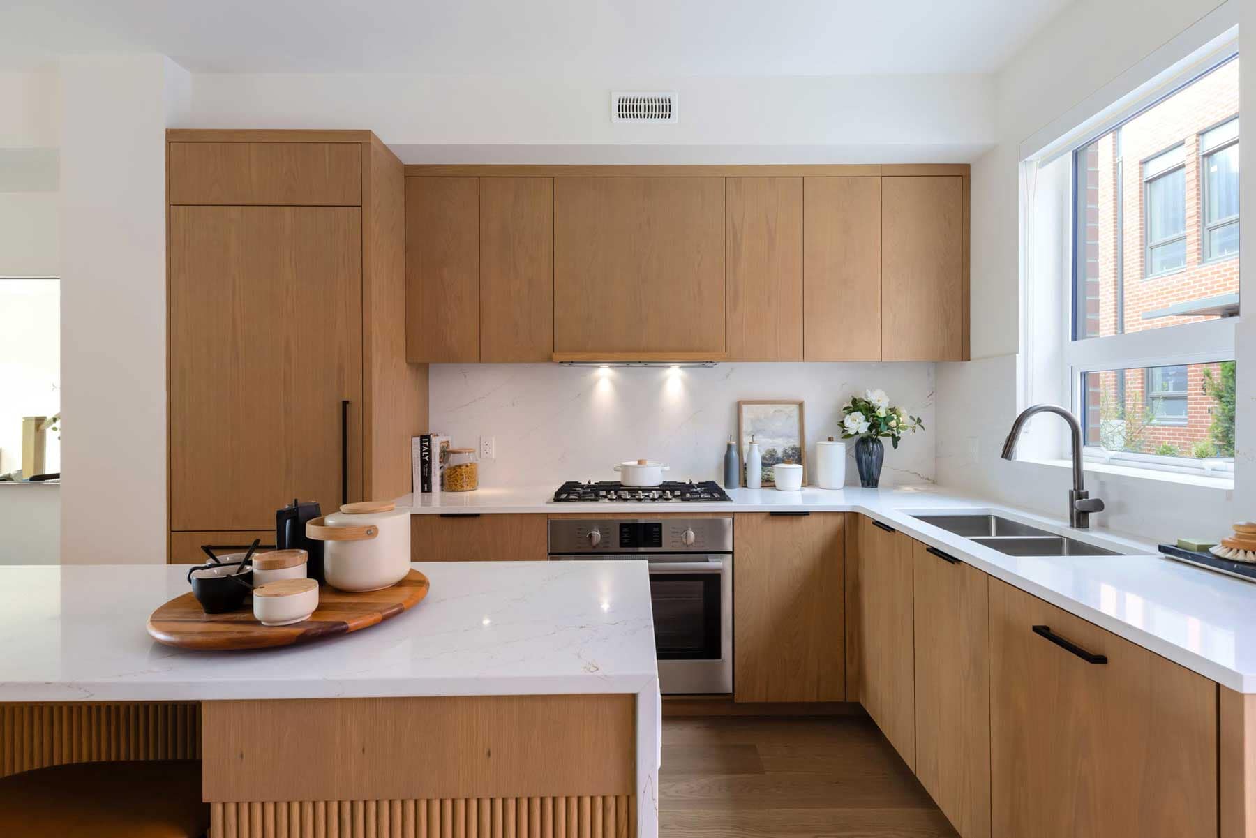 Modern kitchen interior at York Vancouver by Listrator, located at 802 West 37th Avenue in Vancouver’s Cambie Corridor, featuring oak cabinetry, quartz countertops, integrated appliances, and bright natural light within a presale townhome.