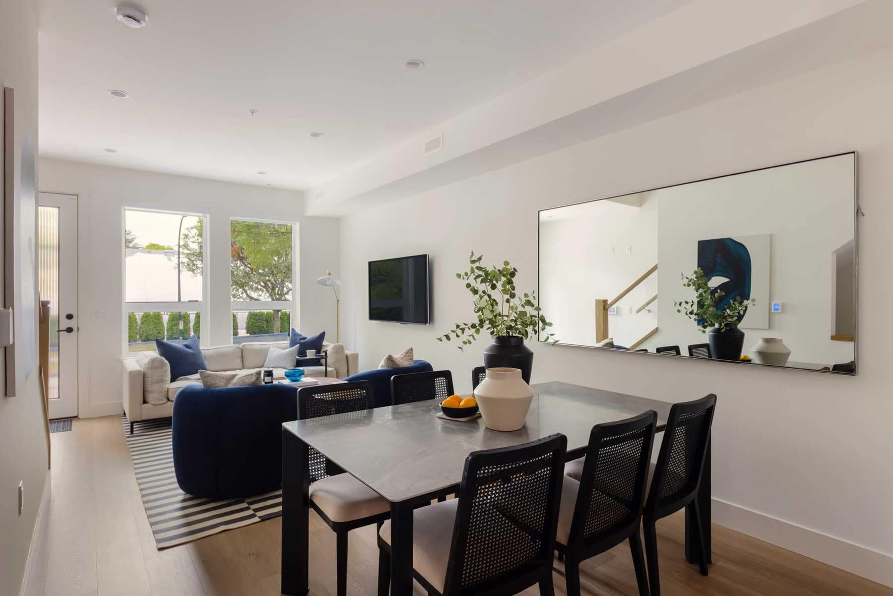 Open-concept living and dining area inside York Vancouver townhomes in Vancouver’s Cambie Corridor, developed by Listrator at 802 West 37th Avenue, featuring wide plank flooring, large windows, modern furnishings, and spacious family living areas.