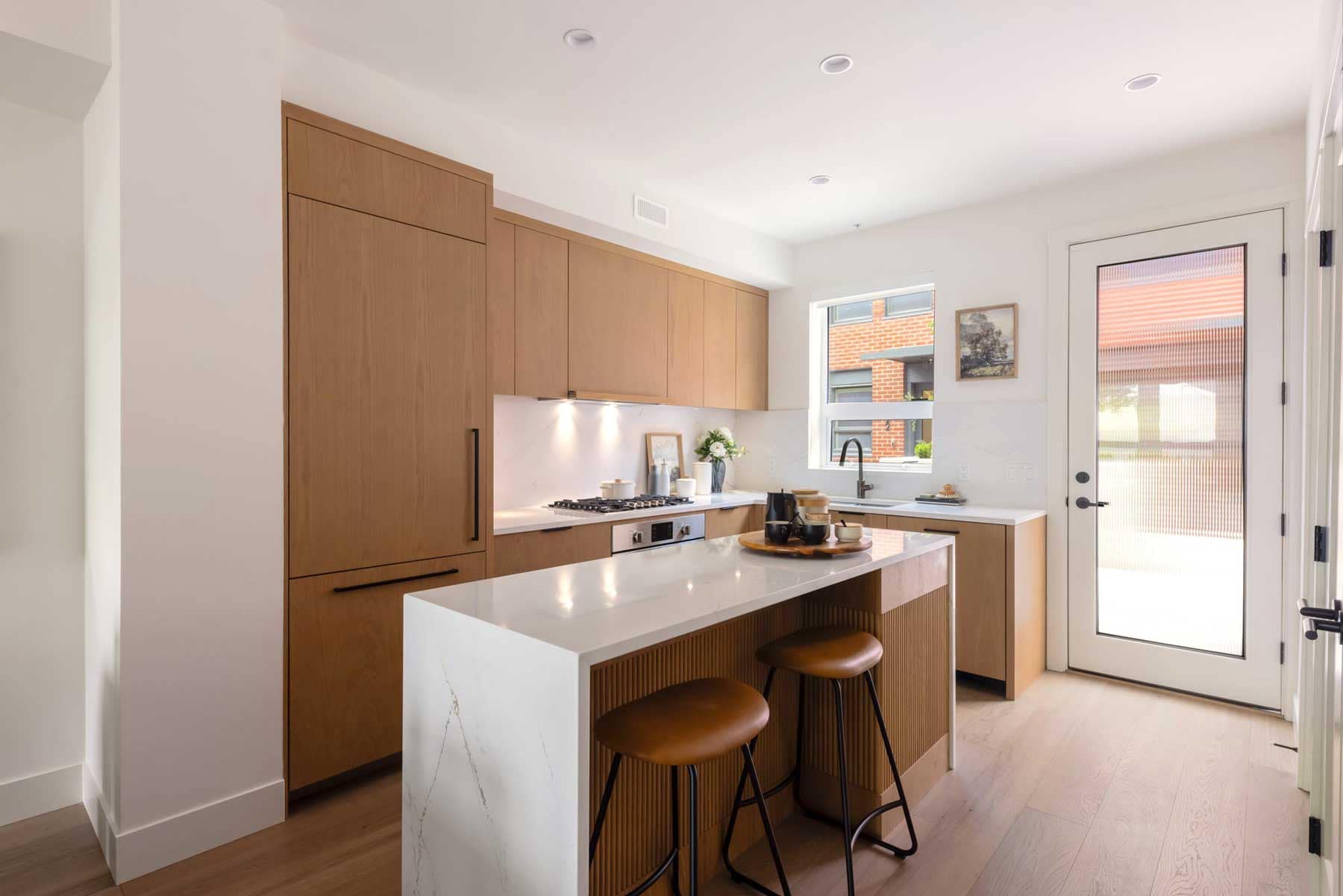 Contemporary kitchen with waterfall island and custom cabinetry inside York Vancouver townhomes by Listrator at 802 West 37th Avenue in Vancouver’s Cambie Corridor, showcasing bright interiors and modern family-focused design.