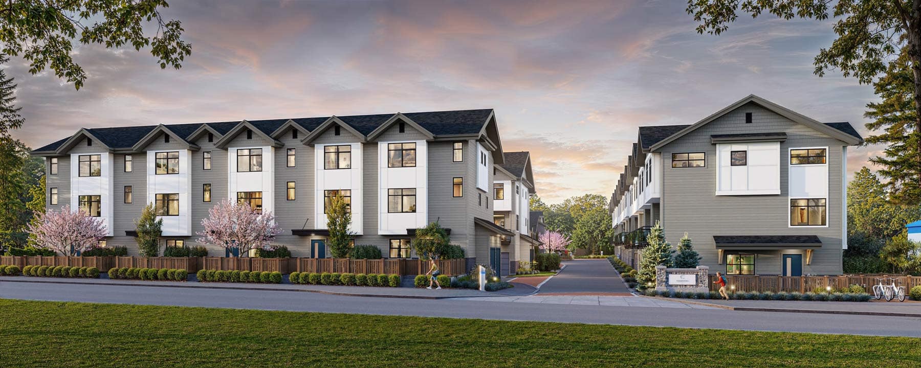 Wide view of Charlton Cloverdale townhome community at 17429 59 Avenue by Warwickshire Homes, showing multiple rows of homes, landscaped pathways, and family-friendly outdoor spaces.