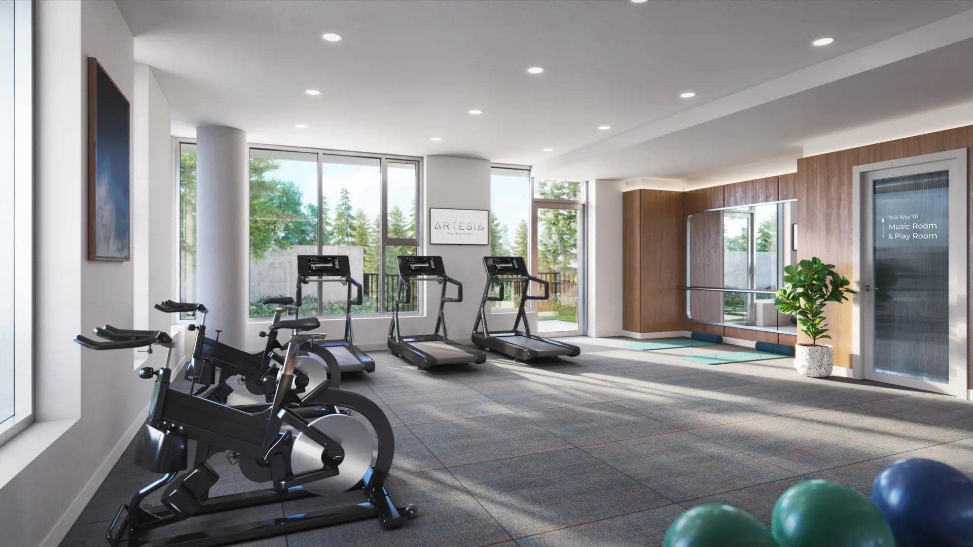 Fitness studio at Artesia Metrotown Burnaby with cardio machines and large windows.