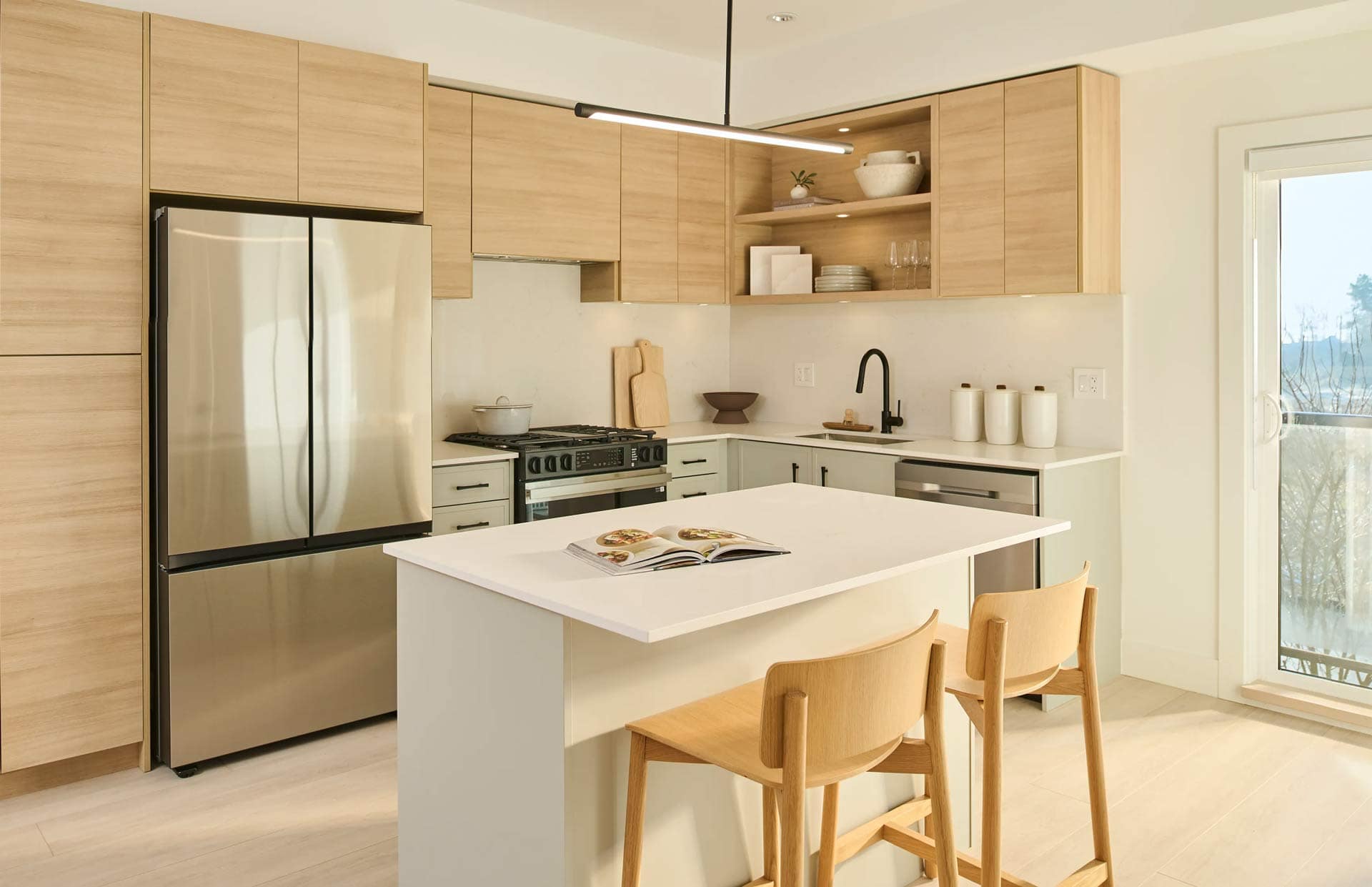 Modern kitchen interior at Addition Langley presale development by Redekop Ferrario Properties at 20335 70a Ave in Willoughby, featuring wood cabinetry, white quartz island, stainless steel appliances, and open layout