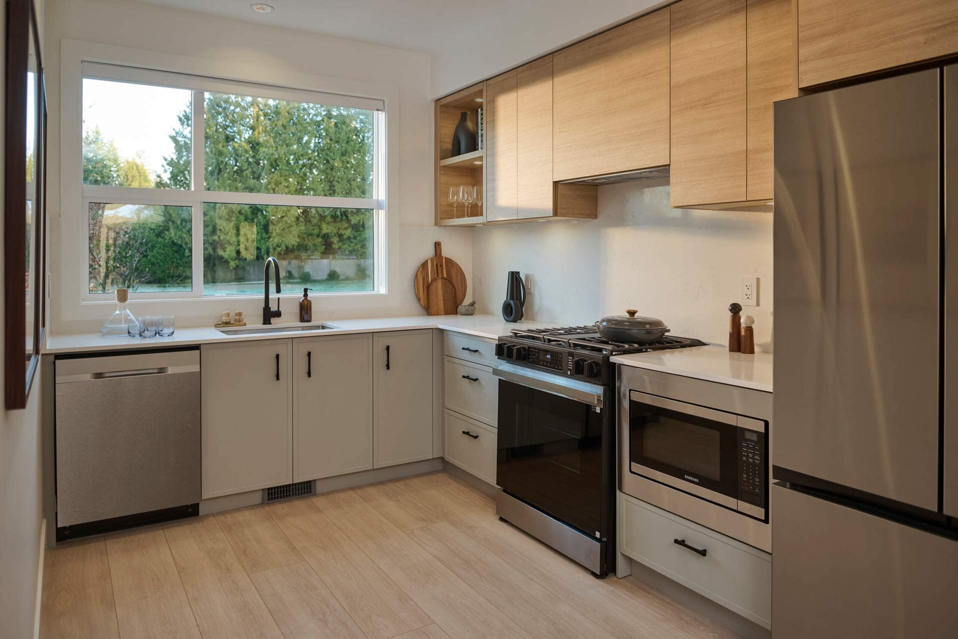 Kitchen at Addition Langley presale homes in Willoughby Langley featuring large window, quartz counters, stainless appliances, and wood cabinetry by Redekop Ferrario Properties