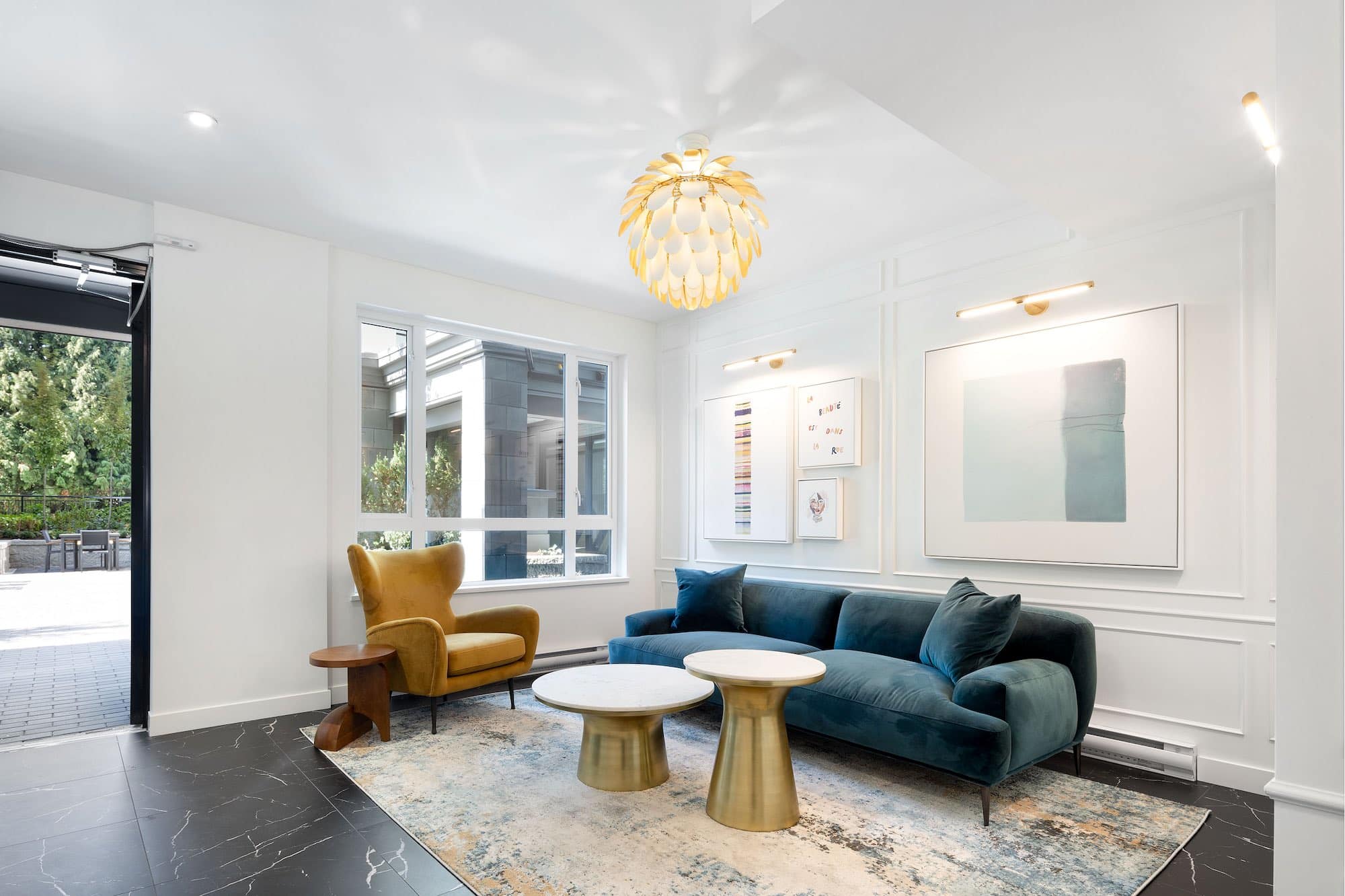 Resident lounge and seating area at Bastille presale condos by Porte Homes in Coquitlam’s Maillardville neighbourhood featuring modern sofas, accent chairs, coffee tables, decorative lighting, and elegant interior design within the shared amenity space at 209 Lebleu Street.