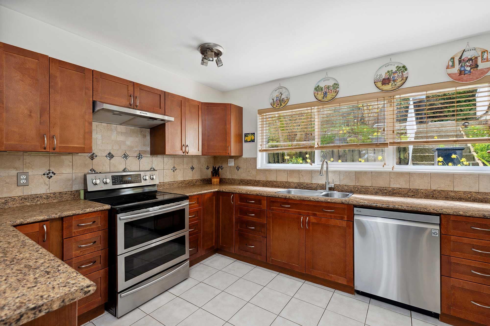 Property listing port moody townhouse for sale kitchen with wood cabinets stainless steel appliances and large window overlooking a front yard