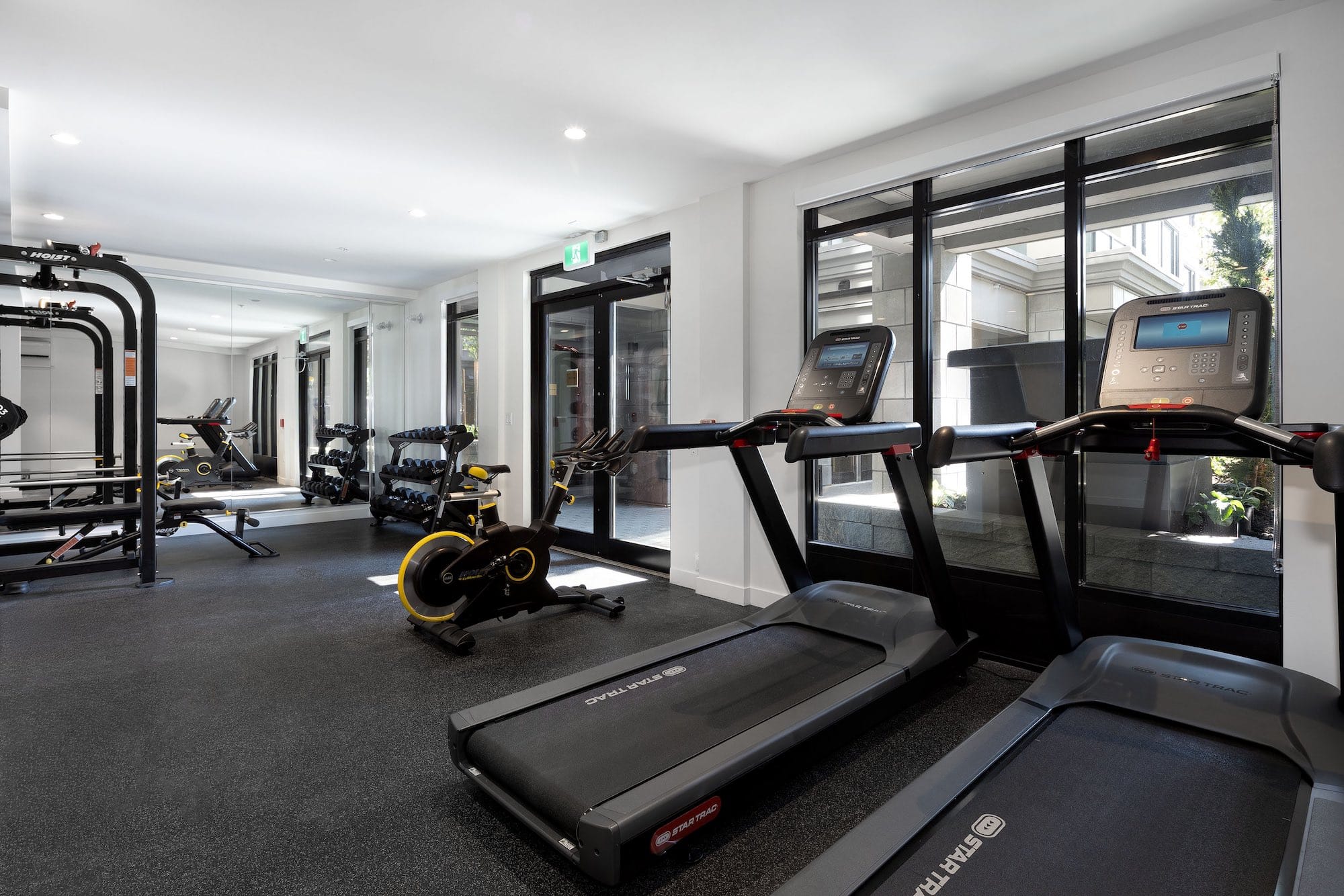 Fitness centre amenity at Bastille presale development by Porte Homes in Coquitlam’s Maillardville neighbourhood featuring treadmills, stationary bike, weight equipment, mirrored walls, and modern workout space for residents at 209 Lebleu Street.