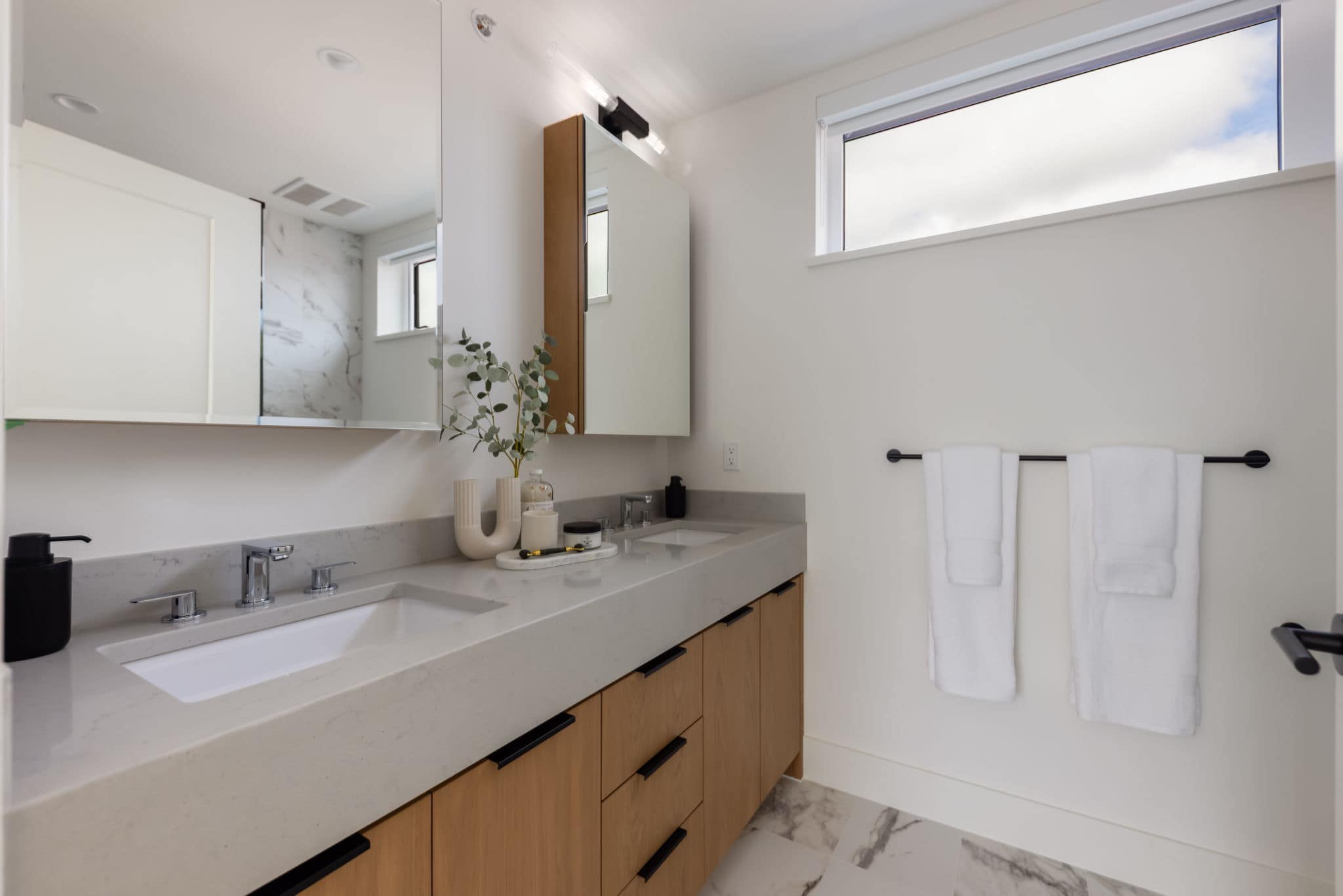 Modern bathroom interior at York Vancouver in Vancouver’s Cambie Corridor, developed by Listrator at 802 West 37th Avenue, featuring a double vanity, quartz counters, wood cabinetry, and large-format tile finishes.