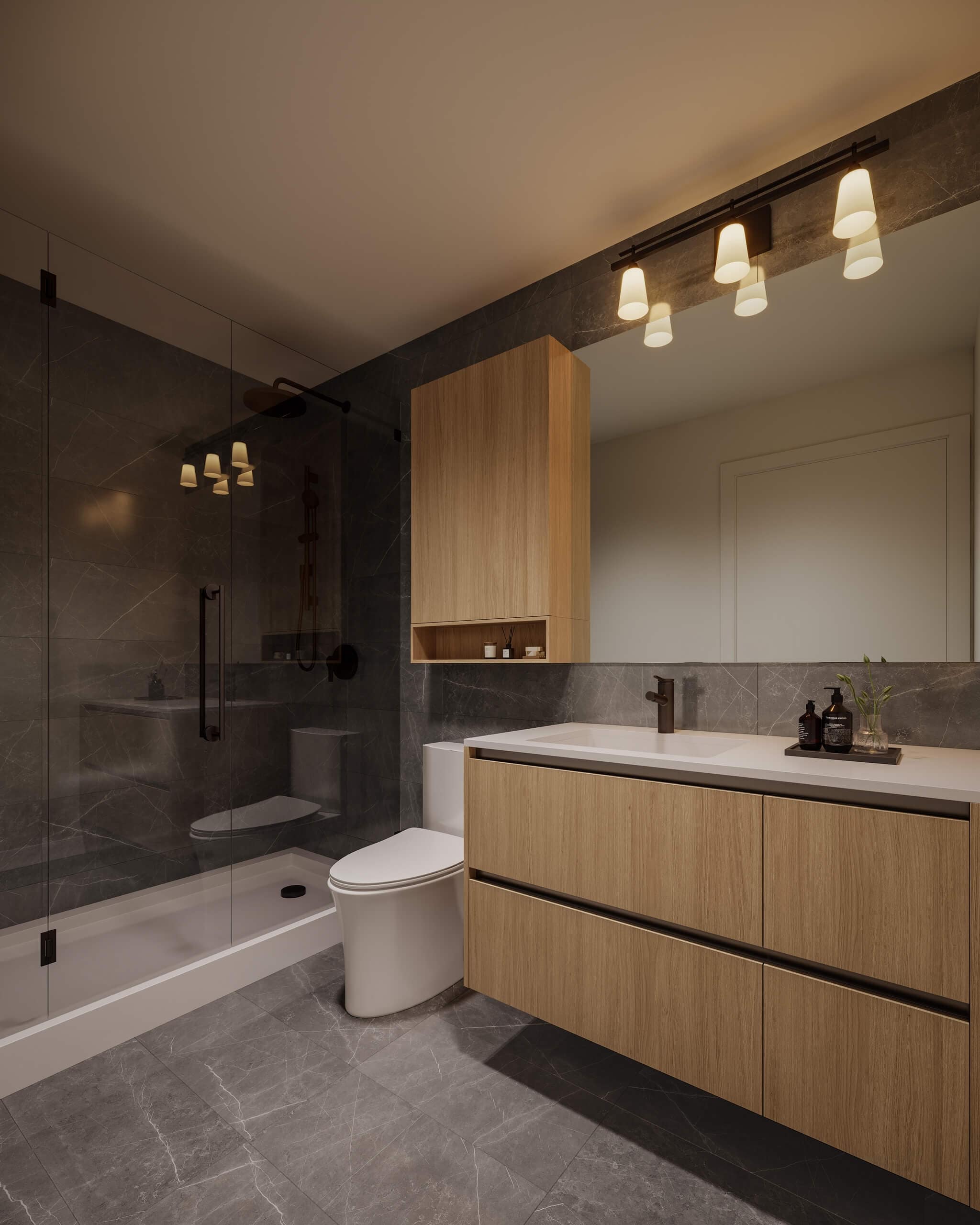 Luxury bathroom interior at Centrale Burnaby showcasing dark stone tile walls, floating wood vanity, frameless shower enclosure, and modern black fixtures at 4488 Hastings Street in Burnaby.