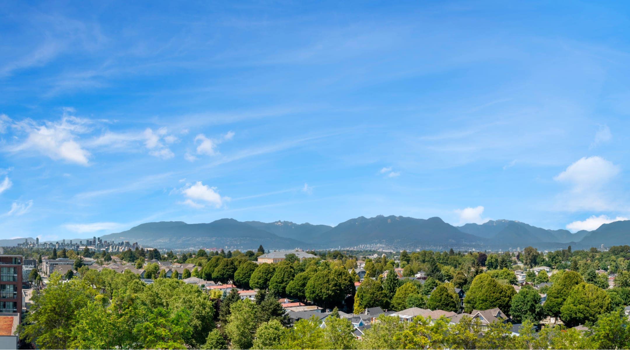 Panoramic view of Collingwood neighbourhood and North Shore mountains near Frame Vancouver at 5189 Earles Street, showcasing green spaces and city skyline.