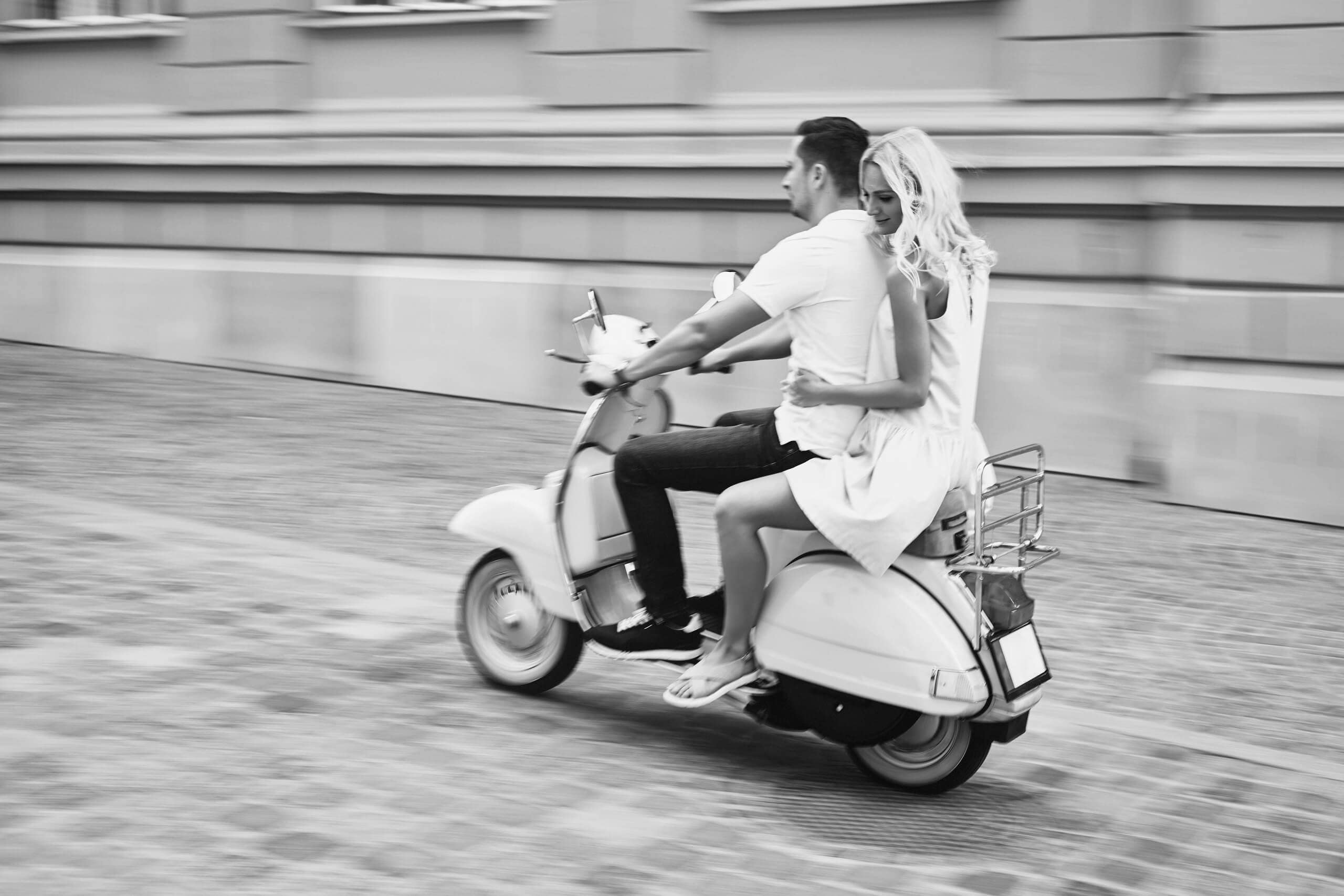 Black-and-white lifestyle image of a couple riding a vintage scooter, reflecting the Italian-inspired lifestyle and design influence behind Centrale Burnaby in Capitol Hill.