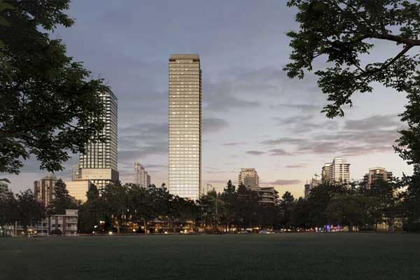 Front-facing view of Solhouse 6035 in Burnaby’s Metrotown neighbourhood, rising beside Central Park and surrounded by mature trees and nearby high-rise buildings, highlighting the tower’s slim profile and park-adjacent location by Bosa Properties at 6035 Wilson Avenue.