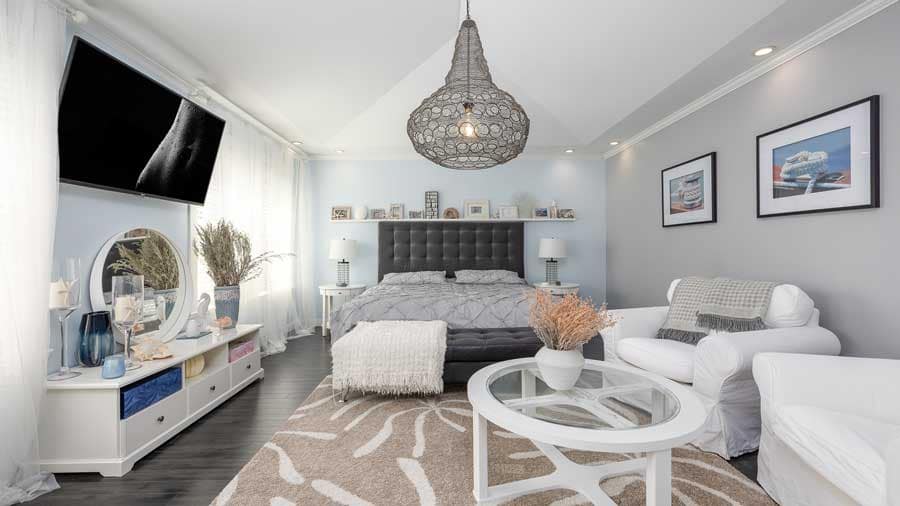 Bright, professionally staged bedroom and living space with neutral tones, layered textures, and modern furnishings, used to represent effective home preparation and presentation when selling in a slow real estate market, highlighting buyer-focused staging, lifestyle appeal, and strategic positioning for Metro Vancouver and Fraser Valley home sellers in 2026.