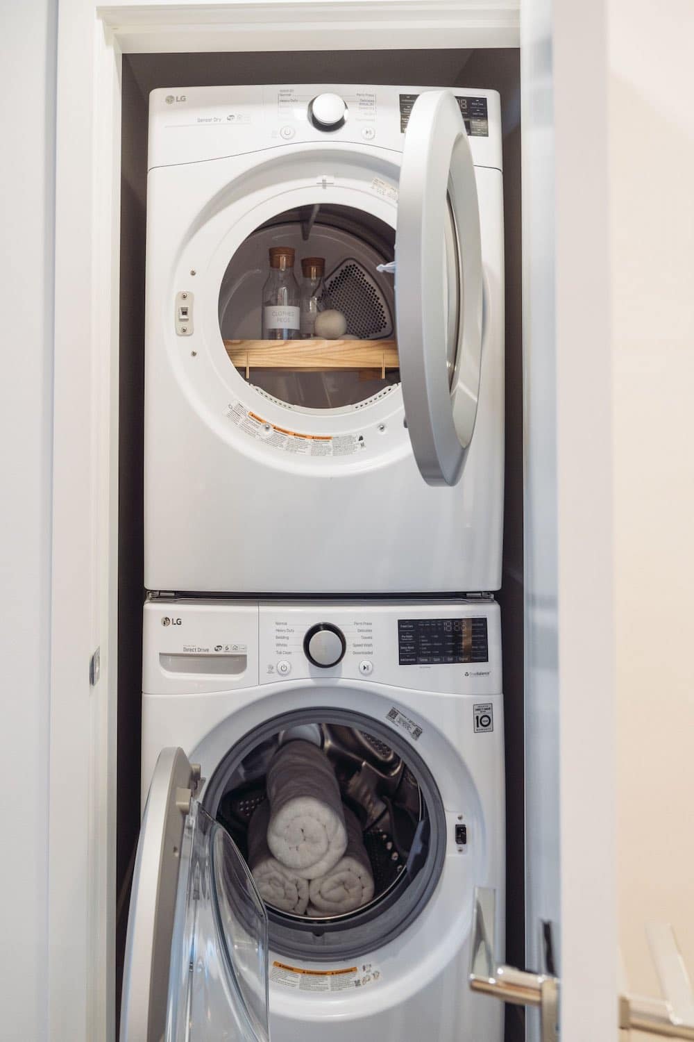 In-suite laundry area inside Soco Two Coquitlam presale condos by Anthem located at 311 Alderson Ave in Coquitlam’s Maillardville neighbourhood featuring stacked LG washer and dryer appliances inside a closet with shelving and storage space above the machines.