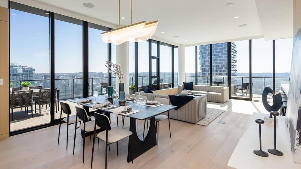 Open-concept living and dining area at 1535 Howe Vancouver by Onni featuring floor-to-ceiling windows, wide plank flooring, contemporary furnishings, and expansive Downtown Vancouver skyline views from the residence at 1335 Howe Street.