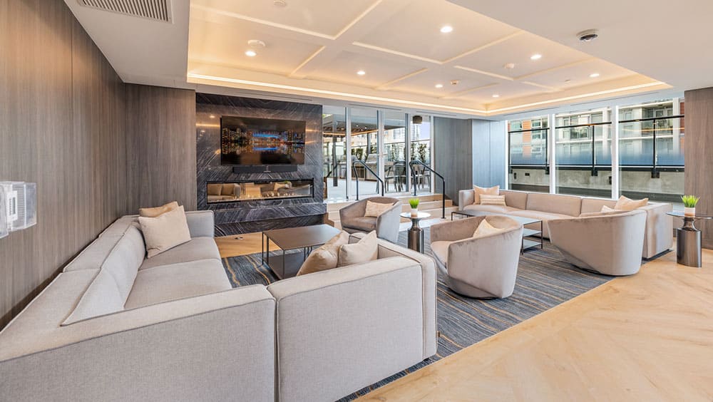 Resident lounge at 1535 Howe Vancouver in Downtown Vancouver featuring modern seating, fireplace, wood panel detailing, and elegant shared amenity spaces developed by Onni at 1335 Howe Street.