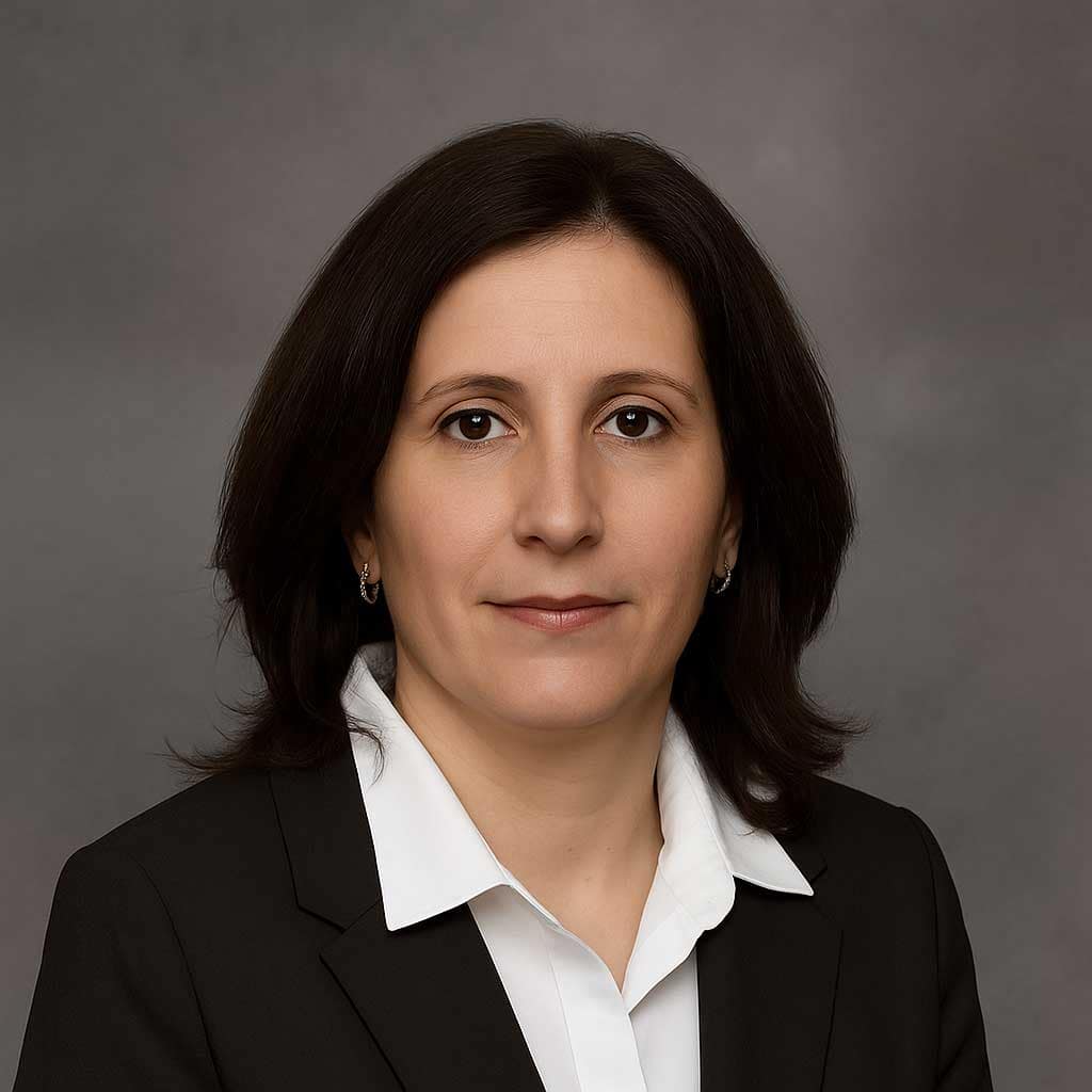 Professional portrait of Claudia Leca, notary public, seated confidently in an office environment.