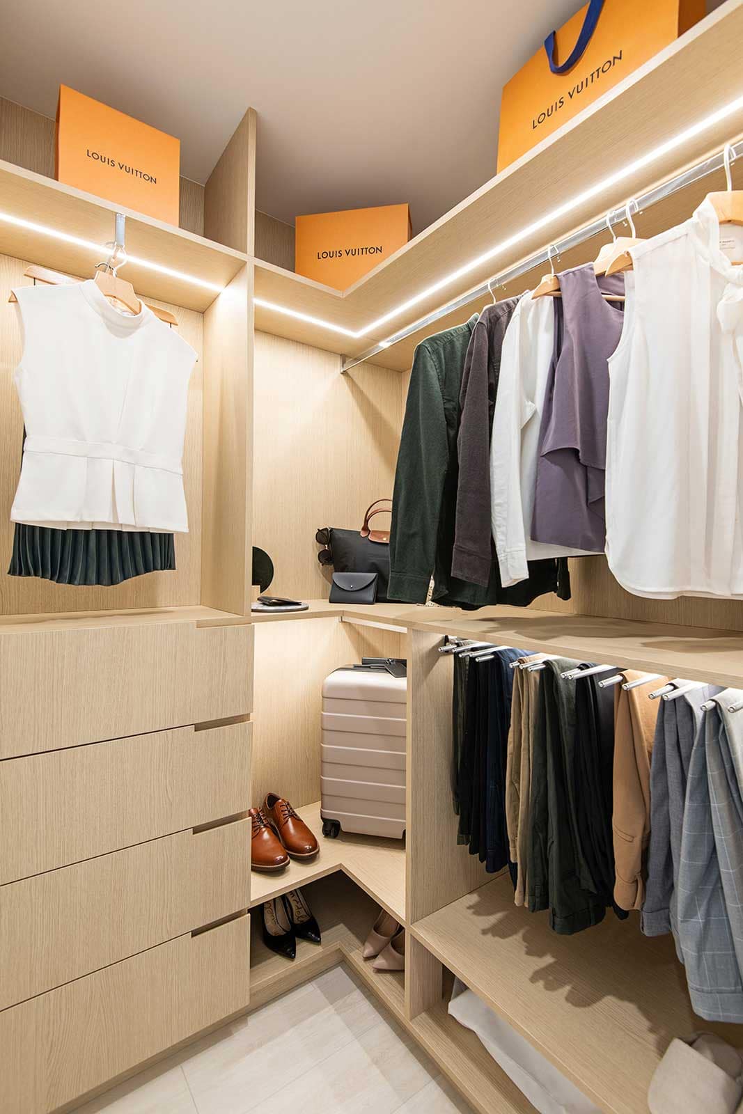 Walk-in closet at Jinju Coquitlam condos by Anthem Properties, located at 533 Cottonwood Avenue in Burquitlam, featuring custom millwork, organized shelving, hanging space, drawers, and integrated lighting for efficient storage.