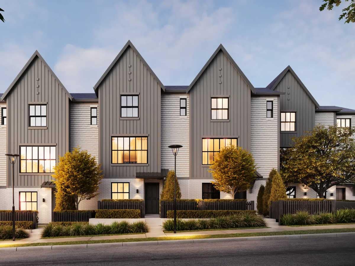 Row of Langley new construction townhomes along a landscaped street at dusk, showcasing exterior design, lighting, and curb appeal.
