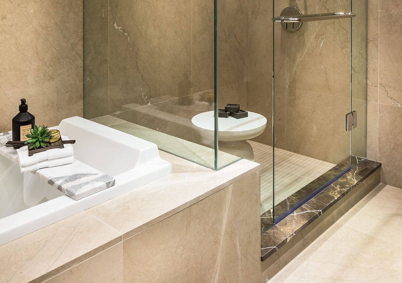 Detailed bathroom view at 1535 Howe Vancouver featuring frameless glass shower, soaking tub, stone tile walls, and luxury fixtures in a residence at 1335 Howe Street Downtown Vancouver.