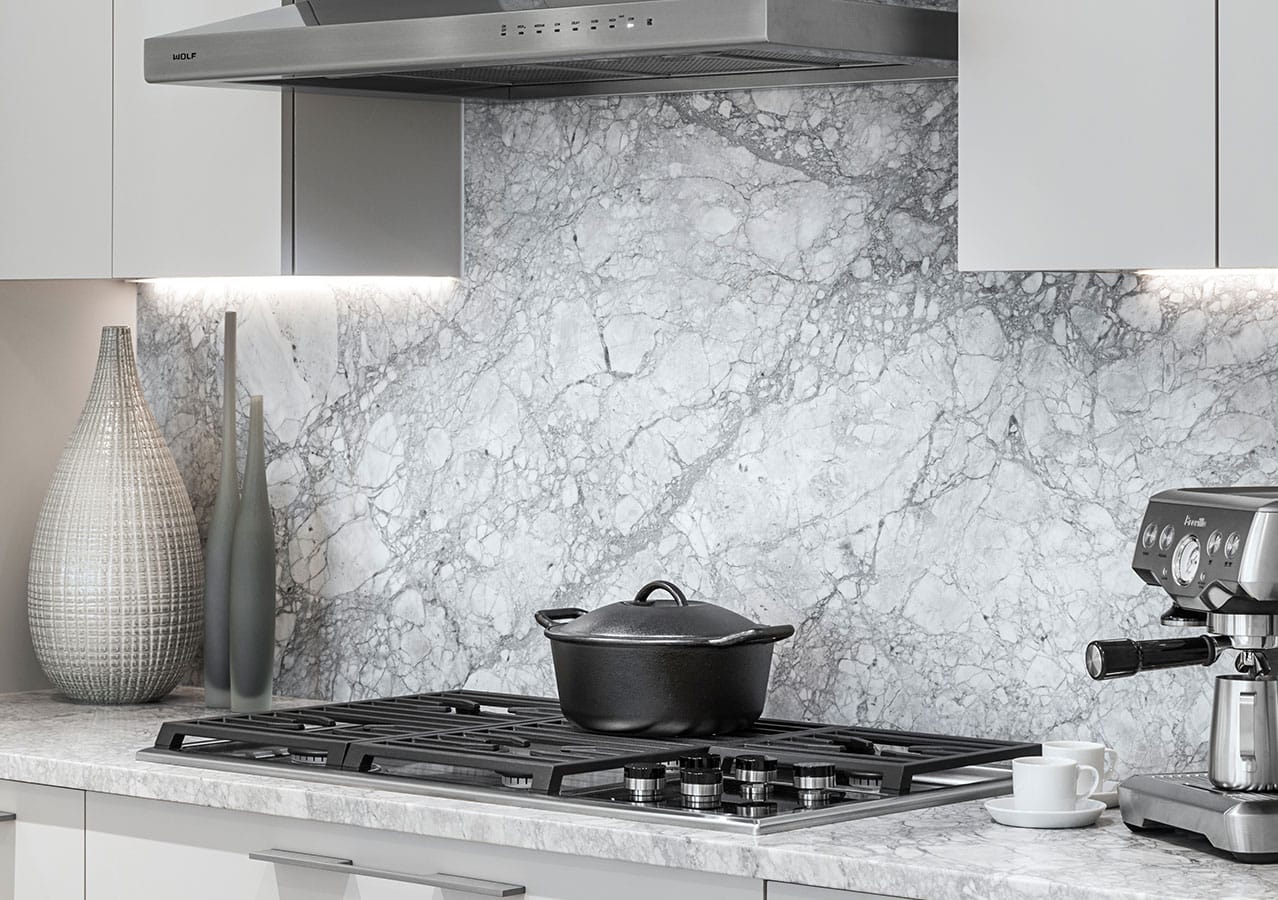 Marble kitchen backsplash and Wolf gas range detail inside a luxury residence at 1535 Howe Vancouver by Onni at 1335 Howe Street in Downtown Vancouver.