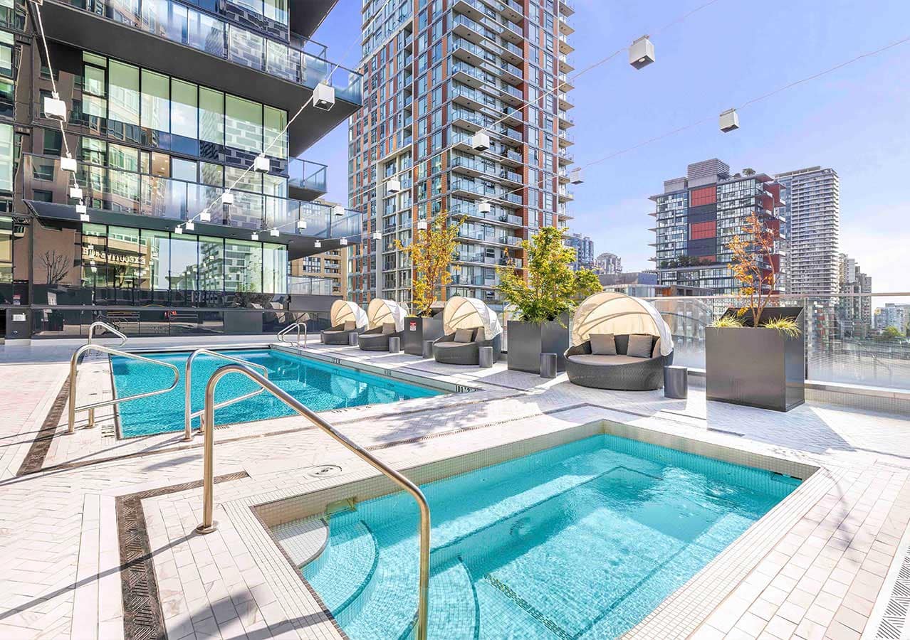 Outdoor swimming pool and hot tub terrace at 1535 Howe Vancouver by Onni with lounge seating, landscaped rooftop amenities, and surrounding Downtown Vancouver high-rise views at 1335 Howe Street.