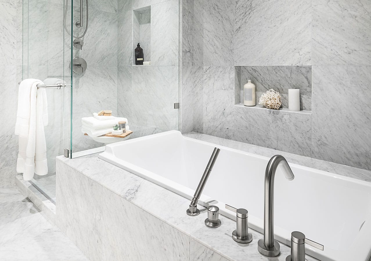 Spa-inspired bathroom at 1535 Howe Vancouver featuring marble tile walls, deep soaking tub, glass shower enclosure, and luxury finishes in a Downtown Vancouver residence at 1335 Howe Street.