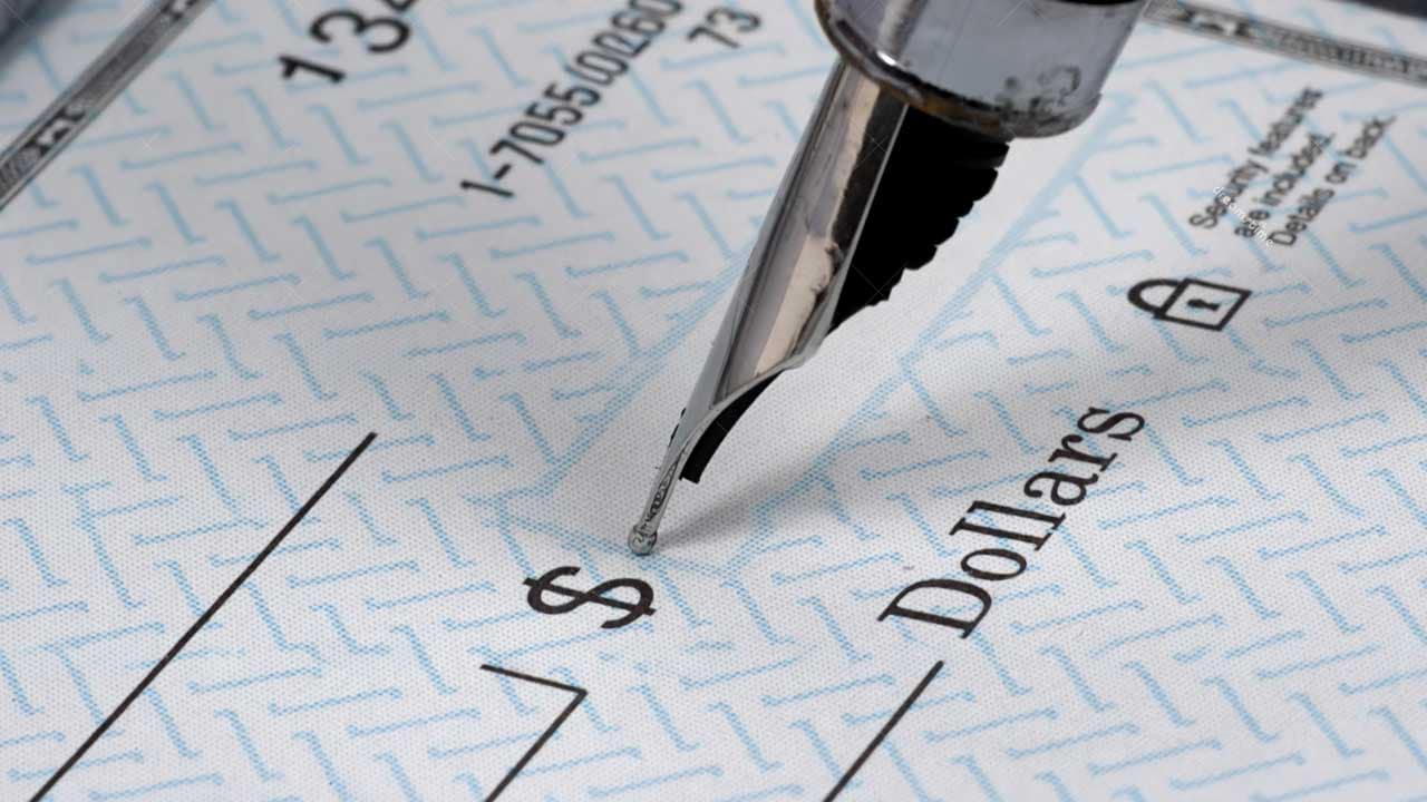 Close-up of a fountain pen signing a cheque, representing a presale condo deposit payment in BC
