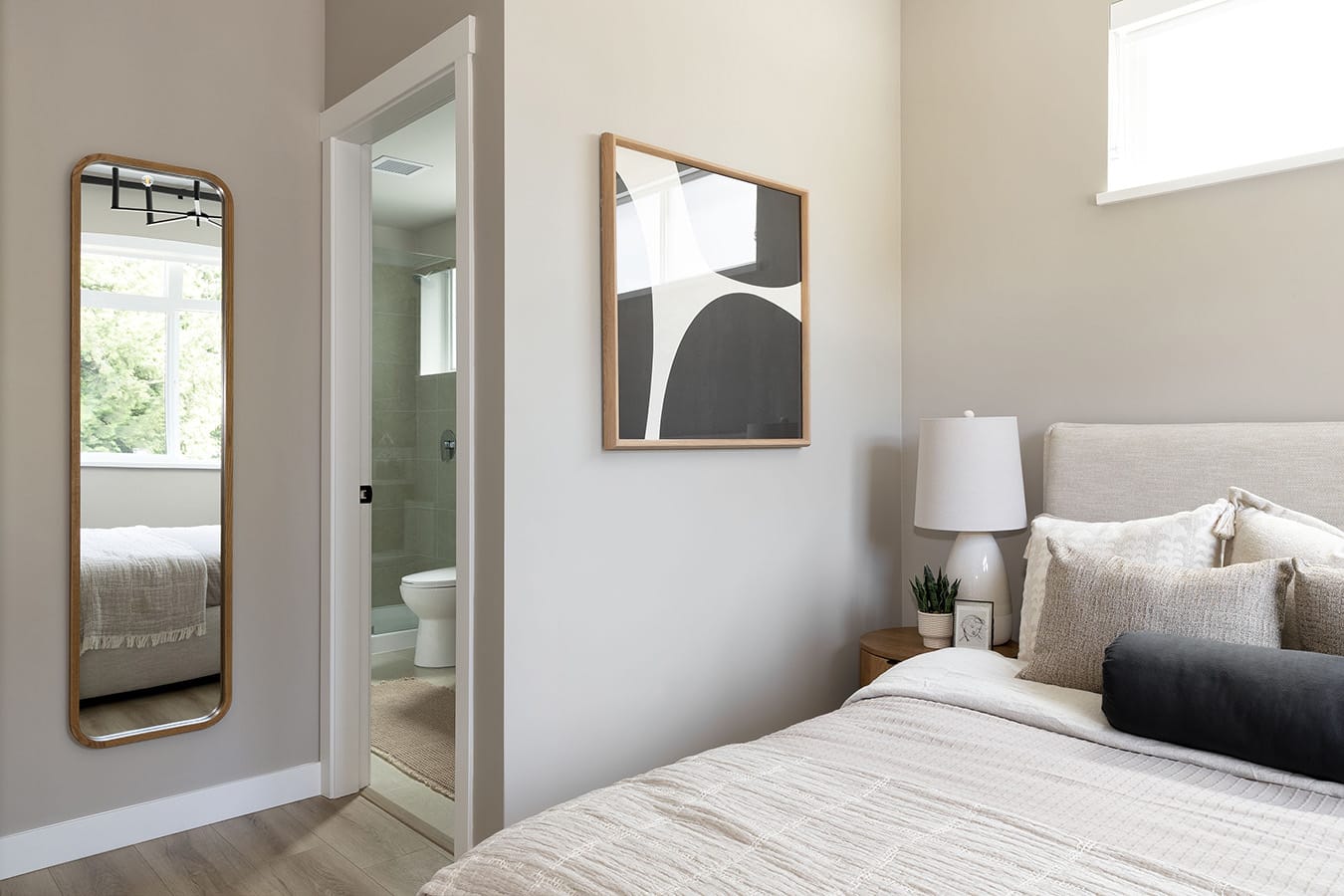 Primary bedroom at Rindall Port Coquitlam featuring soft neutral tones, wide-plank flooring, and an ensuite bathroom in a modern townhome by Woodbridge at 2150 Rindall Avenue.