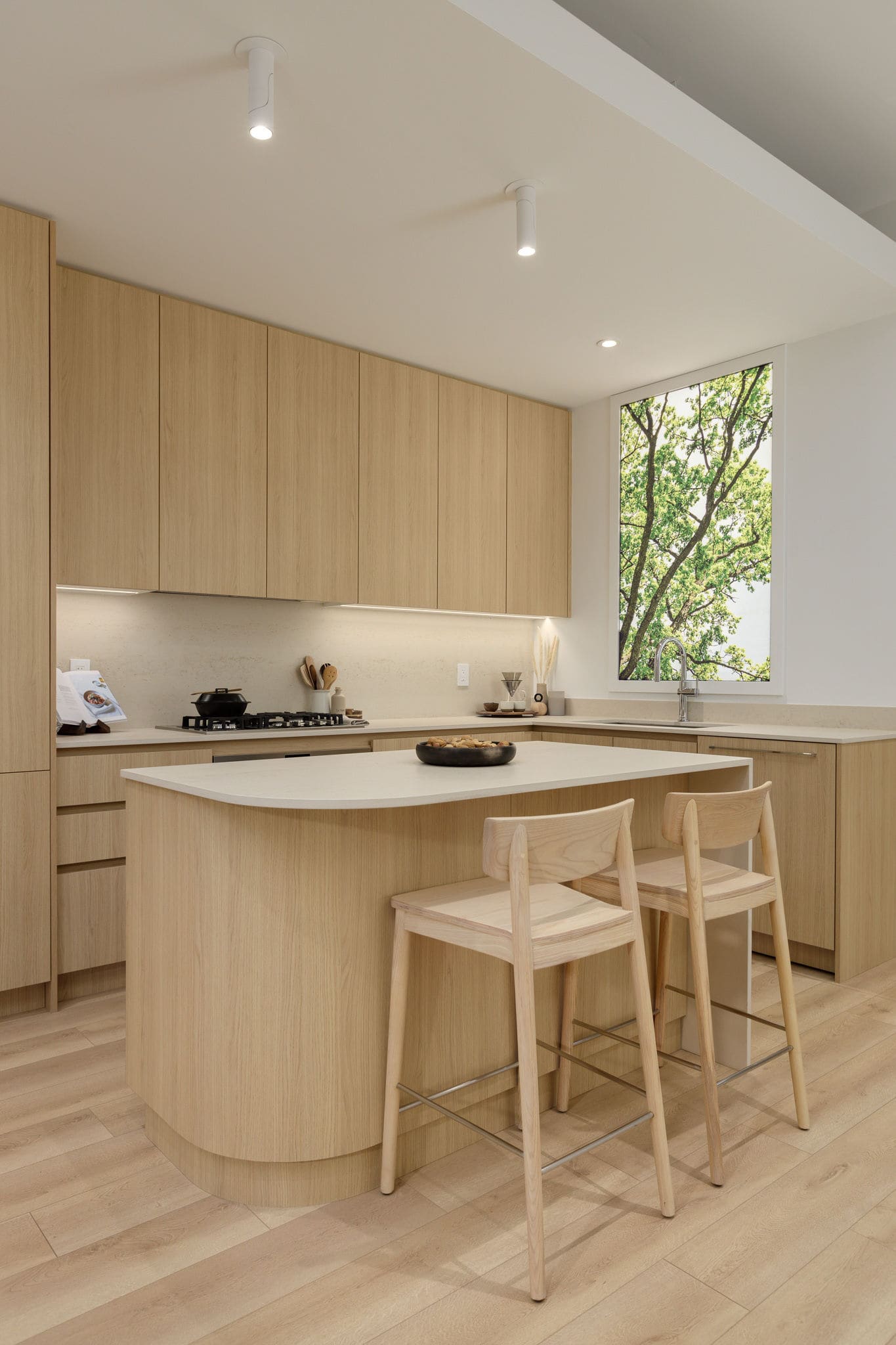 Scandinavian-style kitchen at The Cut in East Vancouver with light wood cabinetry and island.