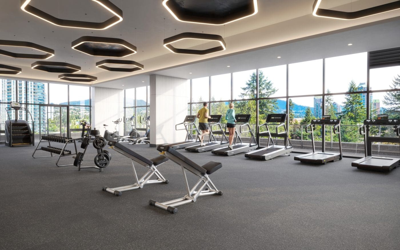 Modern fitness centre at Pine & Glen Coquitlam featuring treadmills, weight training equipment, floor-to-ceiling windows, and mountain views within the Onni Group development at 1175 Pinetree Way.