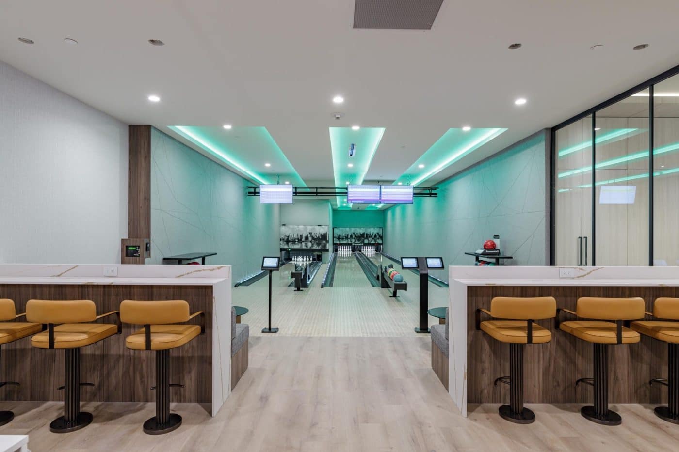 Private bowling lounge at Pine & Glen Coquitlam by Onni Group, featuring bowling lanes, seating areas, modern lighting, and entertainment amenities at 1175 Pinetree Way.