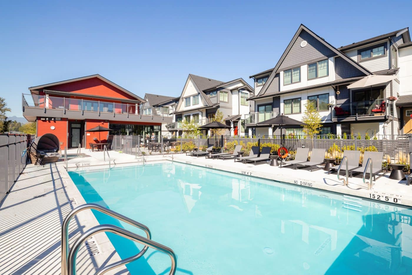 Outdoor swimming pool and lounge area at Nature's Walk Pitt Meadows community by Onni Group at 19451 Sutton Avenue