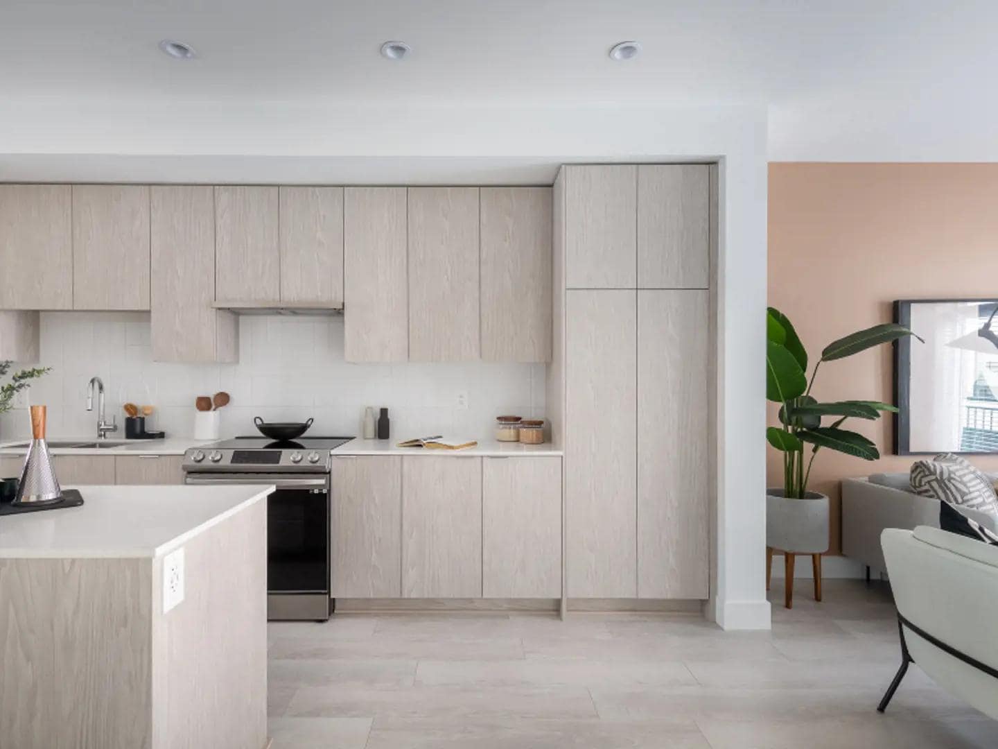 Modern showhome kitchen interior at Chelsea at The Boroughs presale townhomes in Surreyโs Sunnyside Heights neighbourhood, developed by Northwest Development at 16325 21 Avenue, featuring light wood cabinetry, quartz countertops, integrated appliances, and an open concept layout connecting to the living space.
