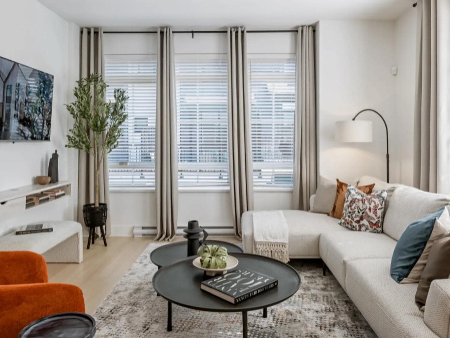 Bright living room interior at Chelsea at The Boroughs presale townhomes in Surreyโs Sunnyside Heights neighbourhood by Northwest Development at 16325 21 Avenue, showcasing large windows with curtains, modern furniture, neutral tones, and an open concept living area designed for comfortable family living.